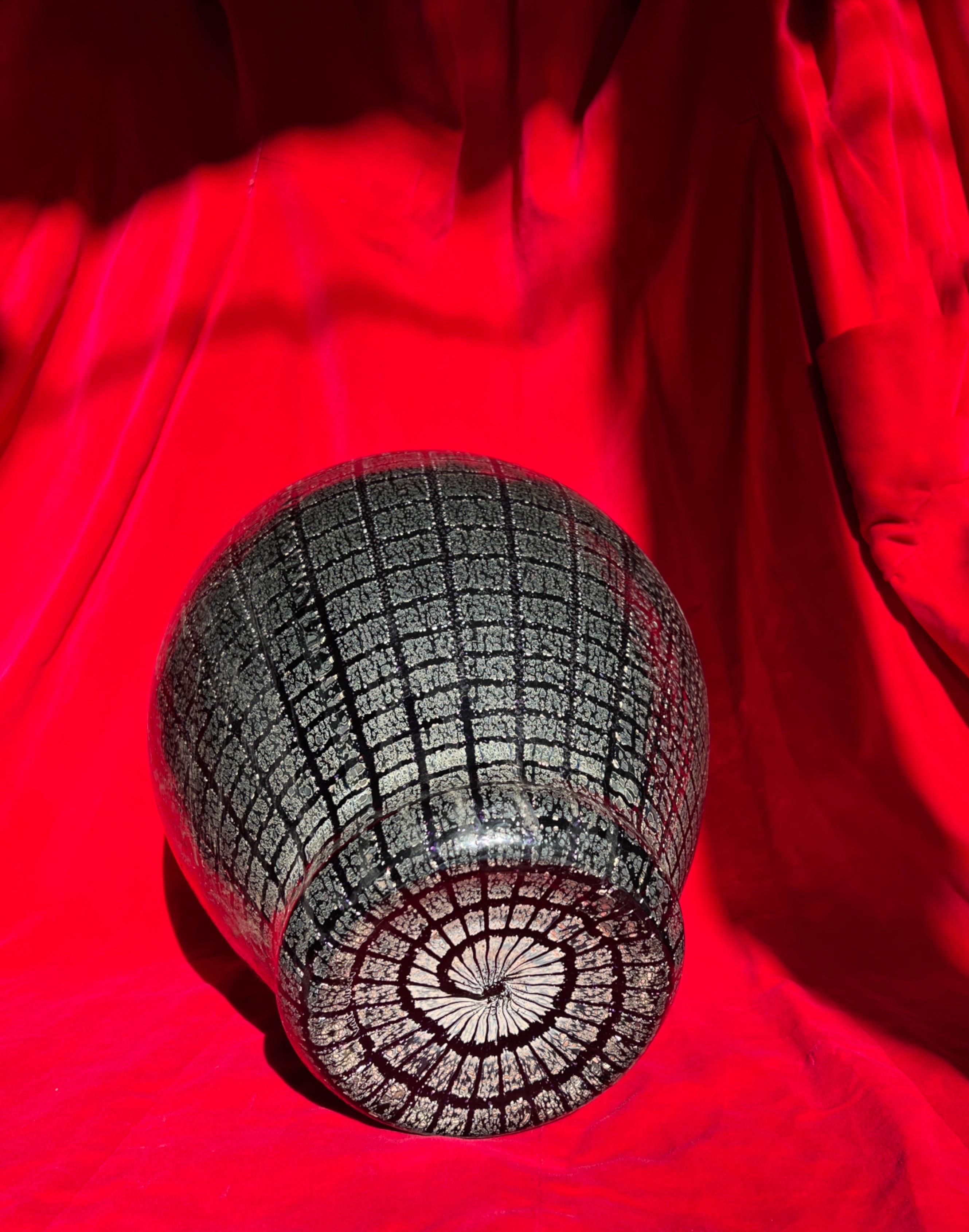 Vaso in vetro di Murano di VeArt, 1980. Questo vaso è caratterizzato da dettagli squisiti: la base nera è ornata da un motivo dettagliato di argento e viola. I colori cambiano a seconda della luce, creando un effetto visivo dinamico e mutevole.