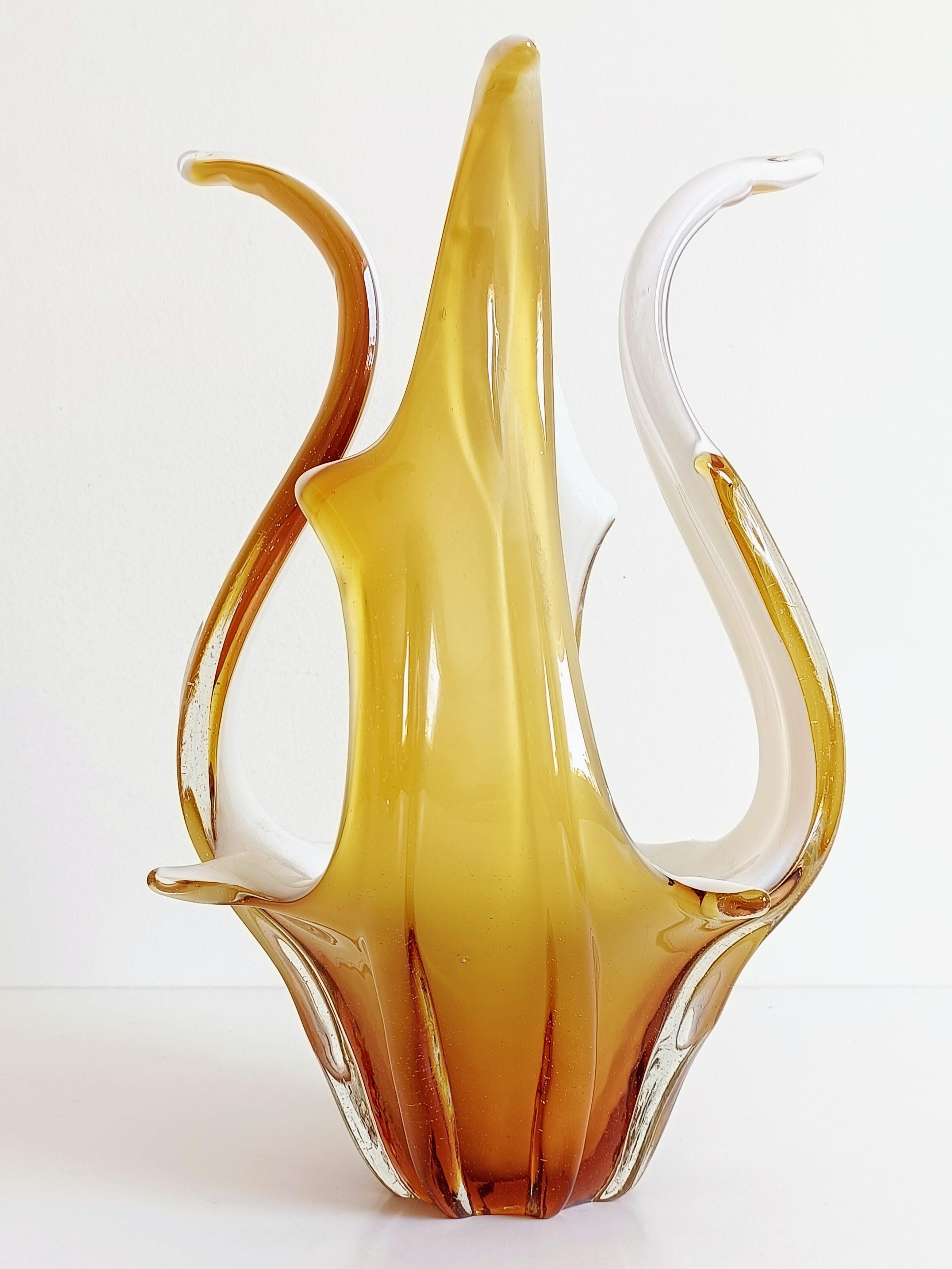 Grande vaso/centrotavola in vetro di Murano della metà del secolo scorso, Italia, anni '60

Elegante e scultoreo, questo vaso in vetro di Murano della metà del secolo scorso presenta forme fluide e arricciate e una sorprendente tonalità ambrata.