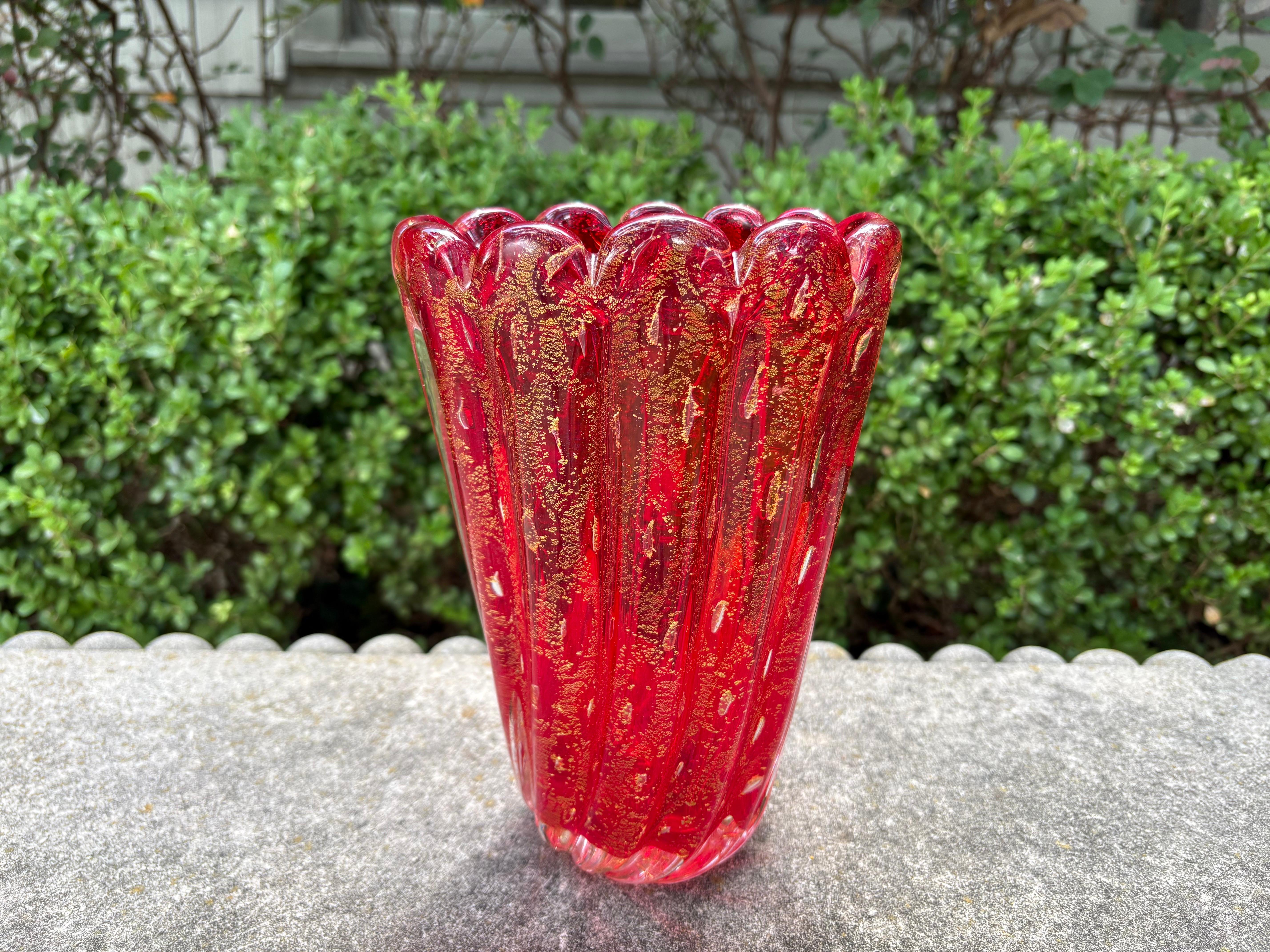 Murano Glass Vase.
Offered is a beautiful hand blown Murano glass vase in a red ribbed design with gold flecks throughout. This lovely Venetian glass vase has an etched signature, Formia Murano.
Lovely!