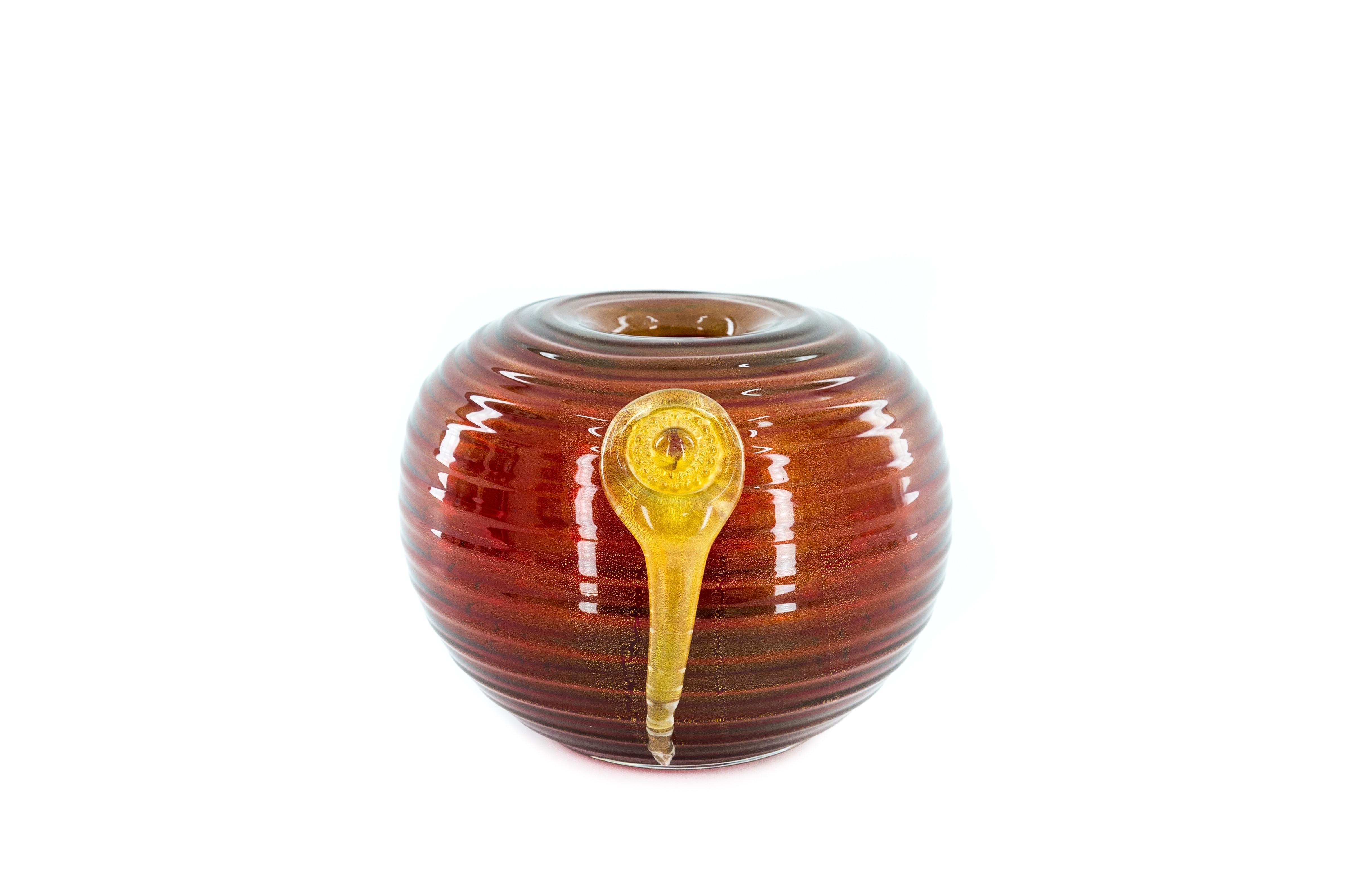 Vase en verre de Murano d'un rouge éclatant orné d'un pendentif central en or Italie années 1980.  

Cet exceptionnel vase en verre de Murano, fabriqué dans les années 1980, est une pièce d'art décoratif saisissante. Sa forme ample, qui rappelle un