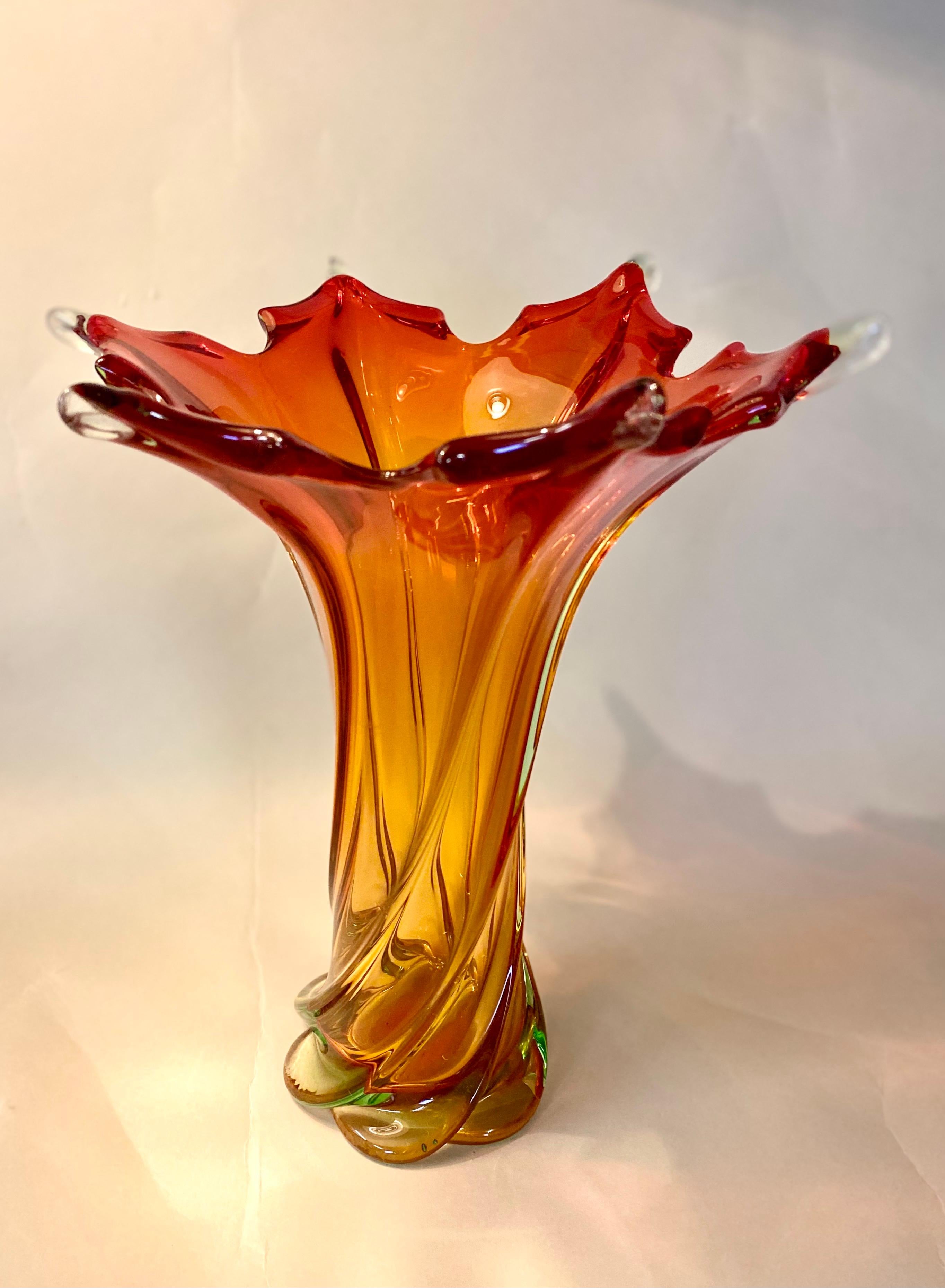 Colorful mid century murano glass vase out of the renown glass art workshops in Italy. Artfully made around 1960/70 this fantastic shaped, large glass vase impresses with a pleasing coloration going from red to lovely orange. The twisted base looks