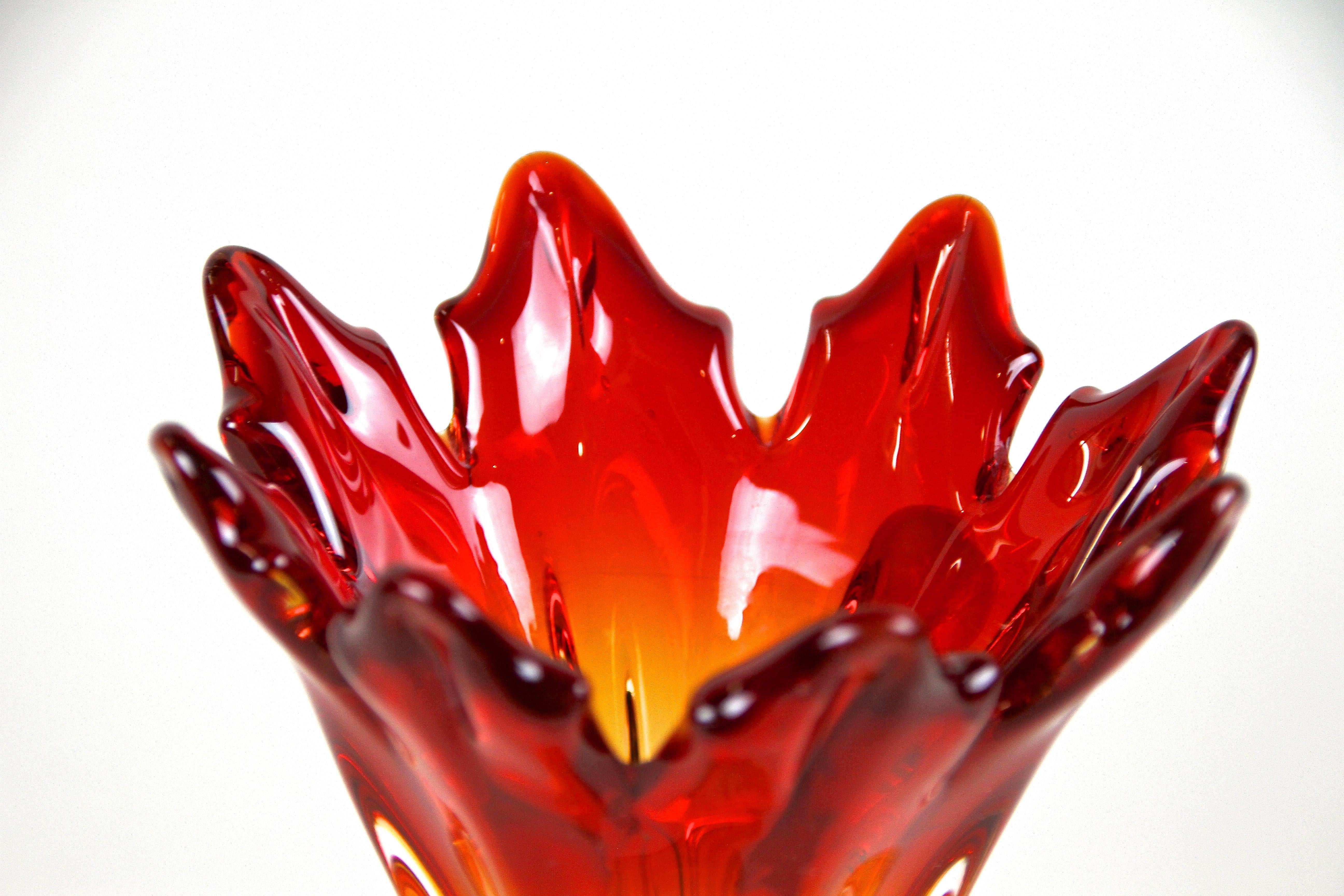Vase coloré en verre de Murano rouge/orange du milieu du siècle, provenant des ateliers d'art verrier renommés de Sommerso sur la petite île de Murano/ Italie. Réalisé avec art vers 1960/70, ce vase en verre de forme fantastique impressionne par son