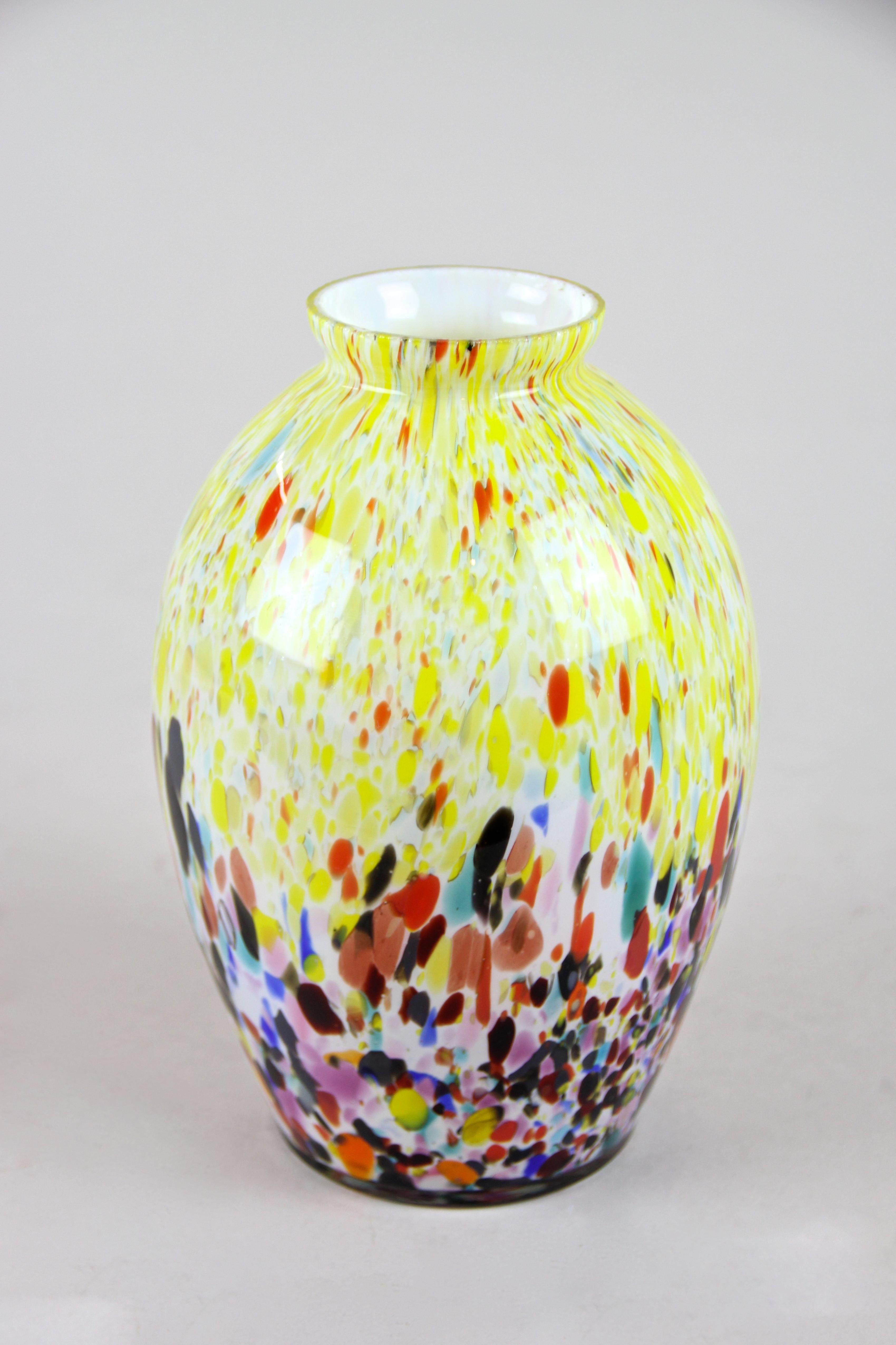 Schöne mehrfarbige Vase aus Murano-Glas aus der Mitte des Jahrhunderts, um 1960. Diese bauchig geformte Glasvase zeigt ein sehr schönes Tupfenmuster in vielen verschiedenen Farbtönen von gelb, blau, türkis, rot, orange bis hin zu rosa und schwarz.