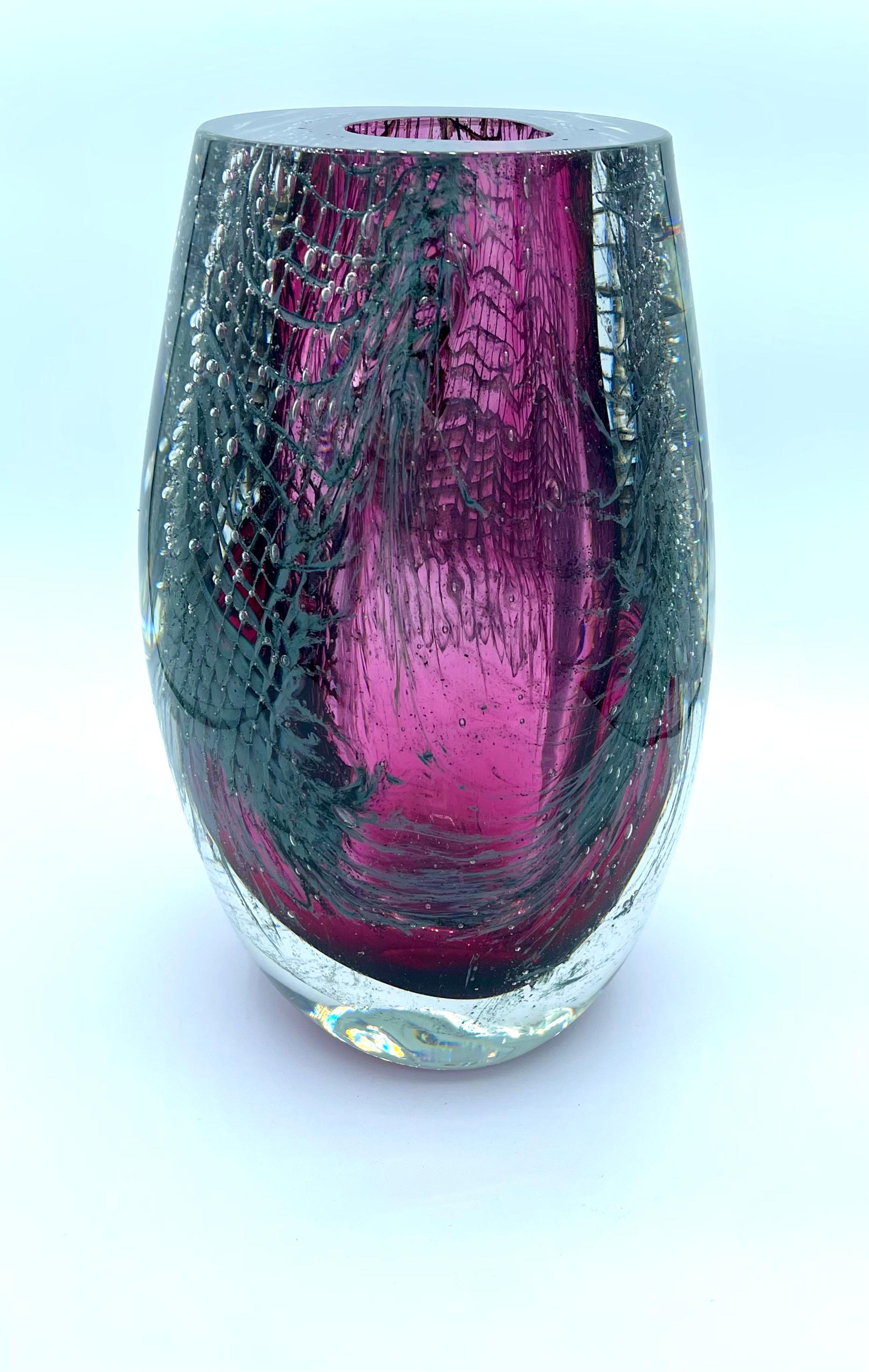 Our vases are crafted by blowing a glass bubble into an aluminum net. Upon contact with the hot glass, the aluminum melts, generating bubbles and leaving behind glossy residues. The color and motion effects of these tiny bubbles lend the structure
