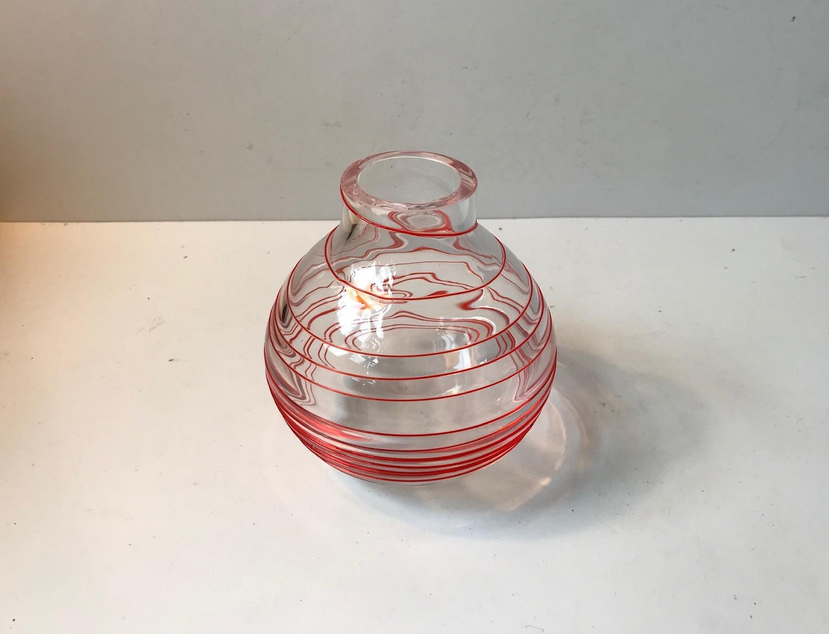 Clear Murano glass vase with overlay red swirl. Manufactured in Venice Italy during the 1960s or 1970s. This design is attributed to Carlo Moretti and inspired the current design of the Nunki vase by Carlo Moretti. Admittedly not executed with its