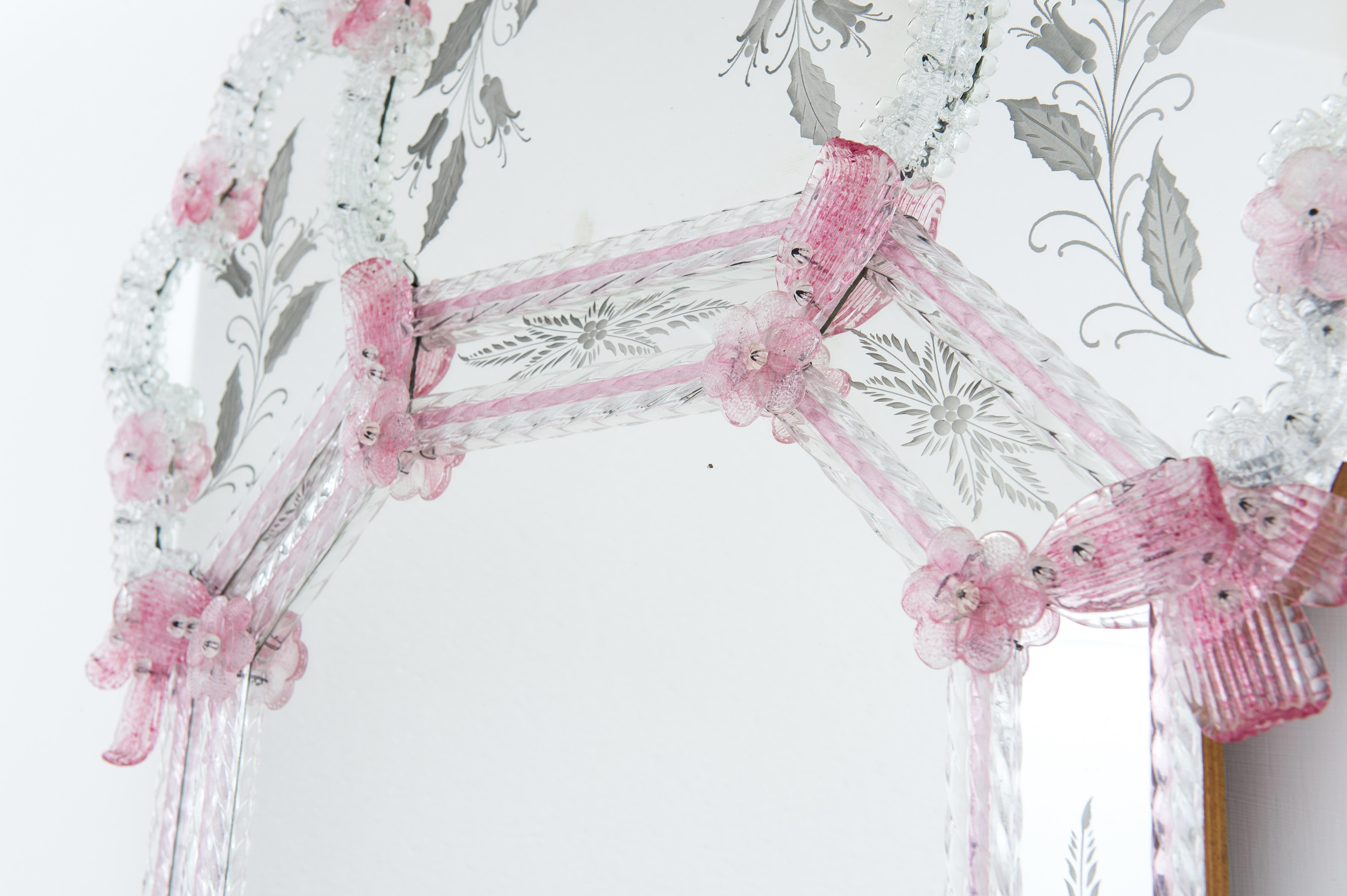 Exquisite Venetian Mirror with Delicate Pink Accents and Engraved Details, contemporary.

Presenting a captivating Venetian mirror, a testament to the enduring artistry and romantic elegance of Murano glass craftsmanship. This exceptional piece,