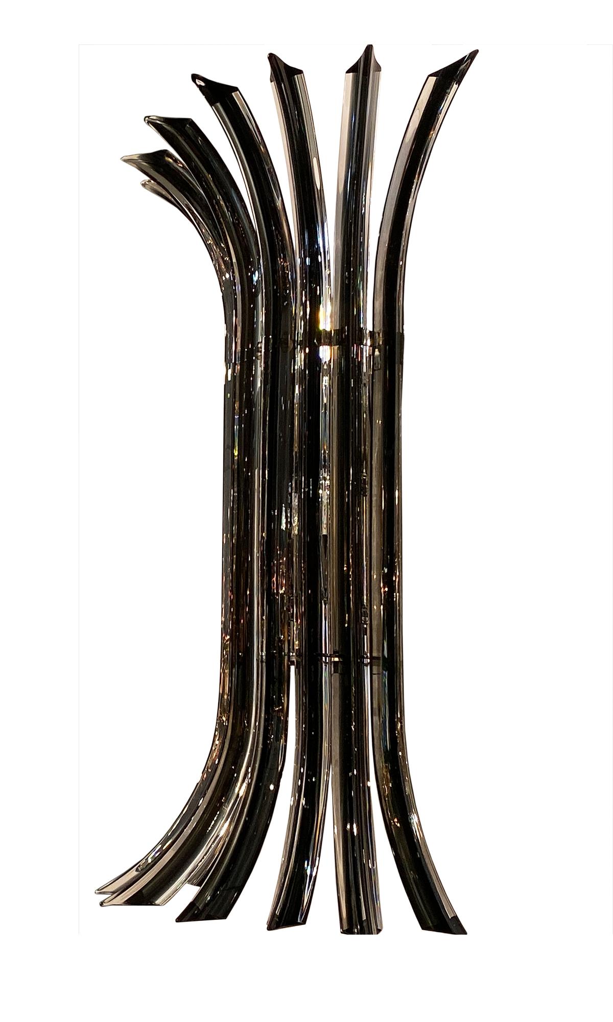 Italian hand blown Murano glass sconces by Venini made of eight curved rods in clear glass with a deep black glass core in the ‘Filigrana’ technique. The light bounces beautifully off the “Triedi” (three faceted) rods, creating a mesmerizing effect.