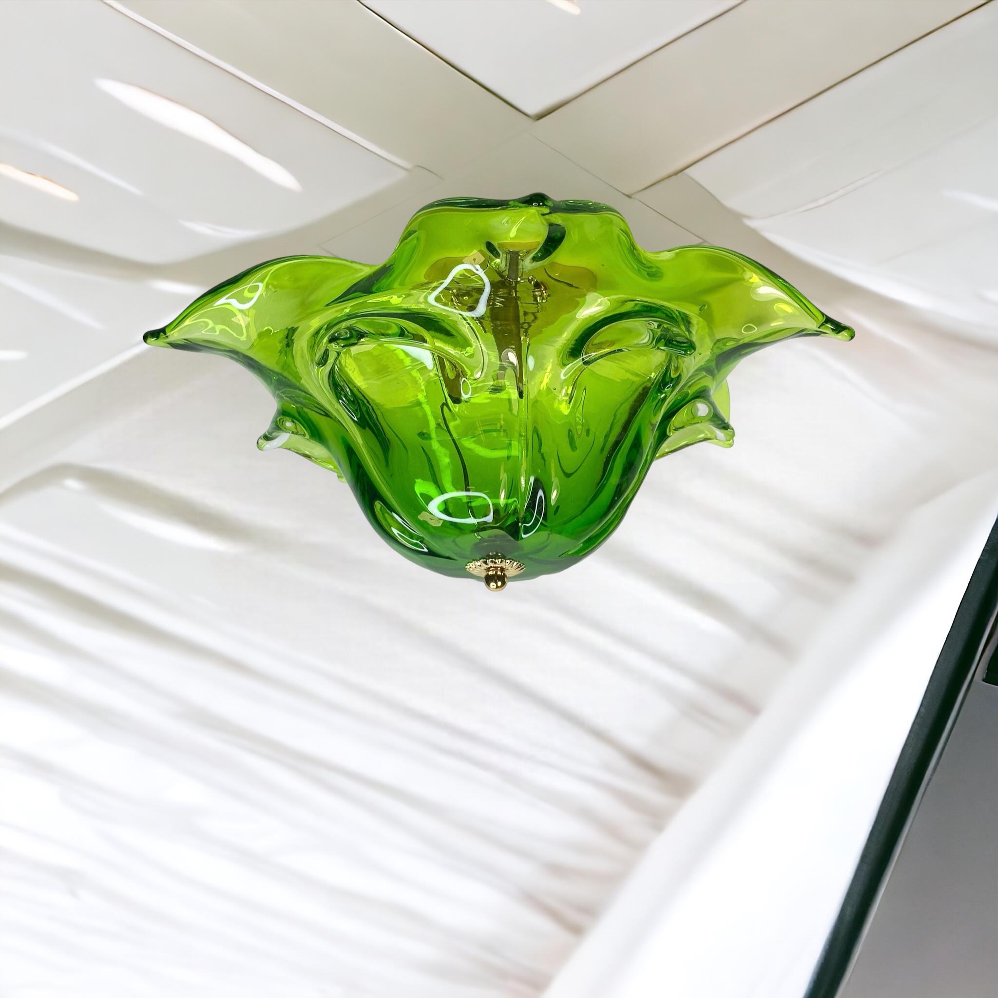 A gorgeous futuristic glass flush mount by a Murano glass company. Heavy mouth blown art glass in an organic technic. The Fixture requires an European E14 / 110 Volt Candelabra bulb, bulb up to 60 watts. Green and clear Murano glass, mounted on a