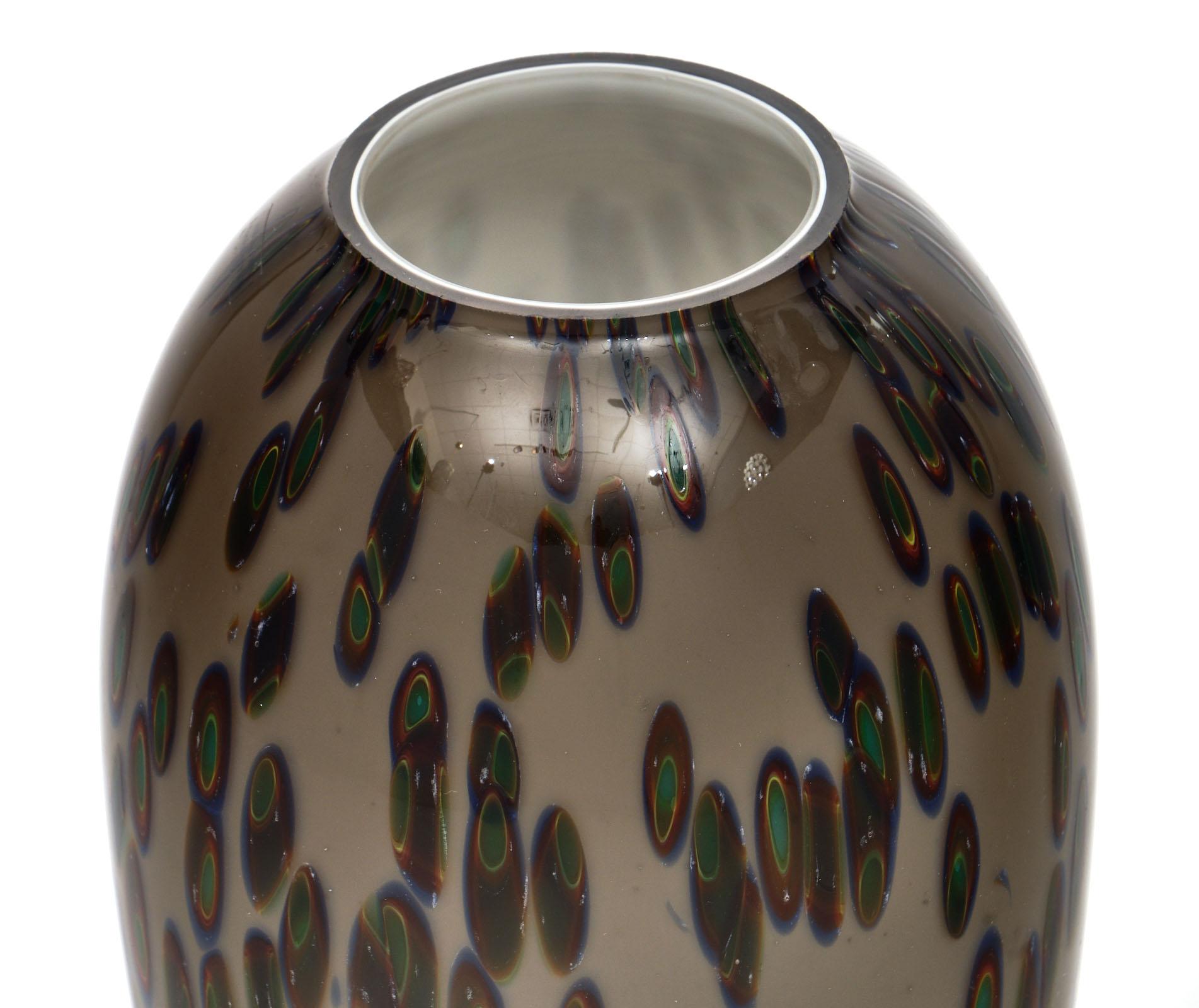 Vintage Murano glass “murrine” vase made by artisans in Italy. This hand blown piece of art features the “murrine” technique - colorful images made in glass cane that are revealed when the cane us cut into cross sections. The vase is then finished