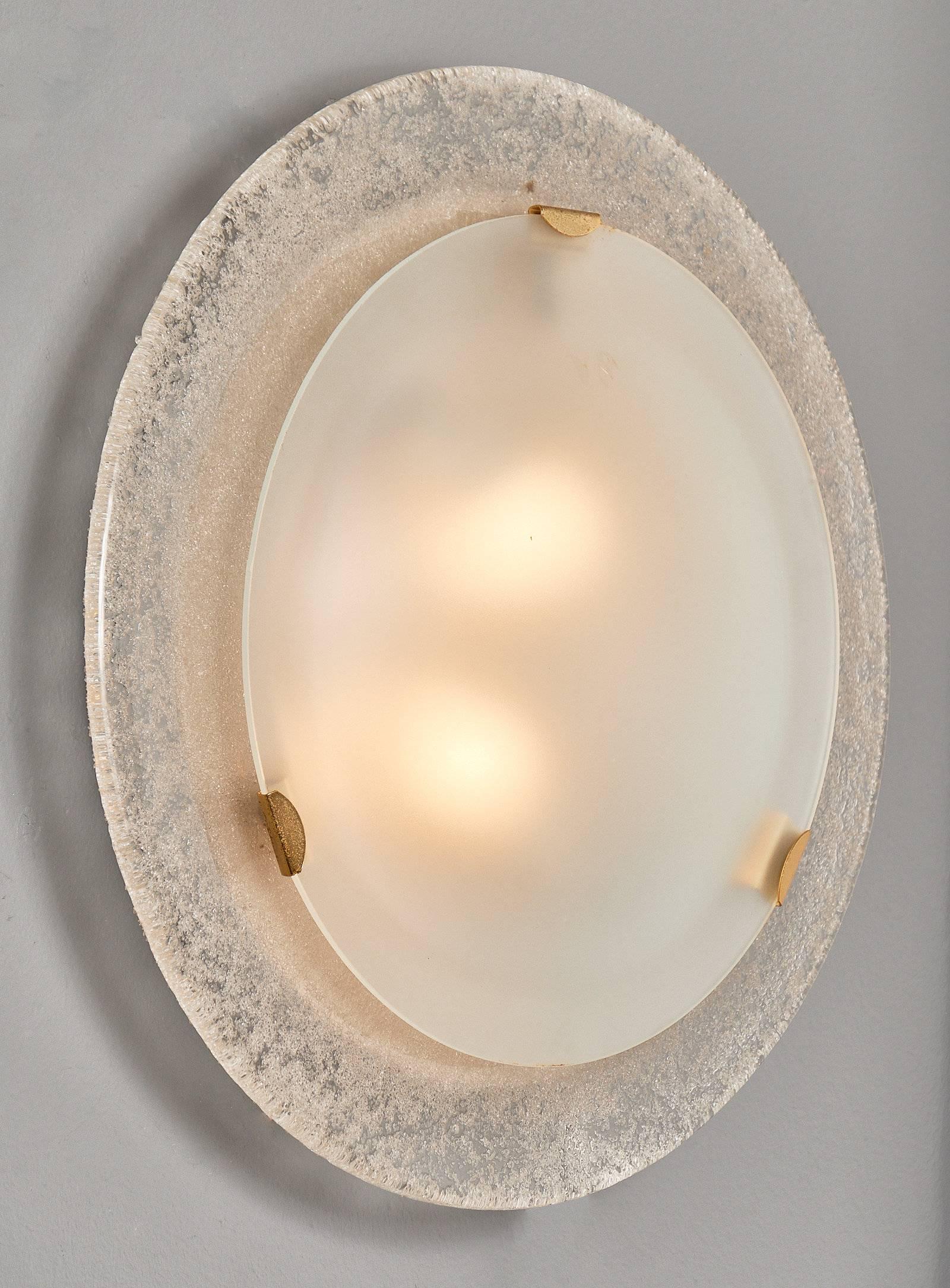 Pair of vintage Murano glass round wall sconces. We love the spherical forms combining frosted and textured glass. Brass hardware accent the pair. These sconces have been wired to fit US standards.