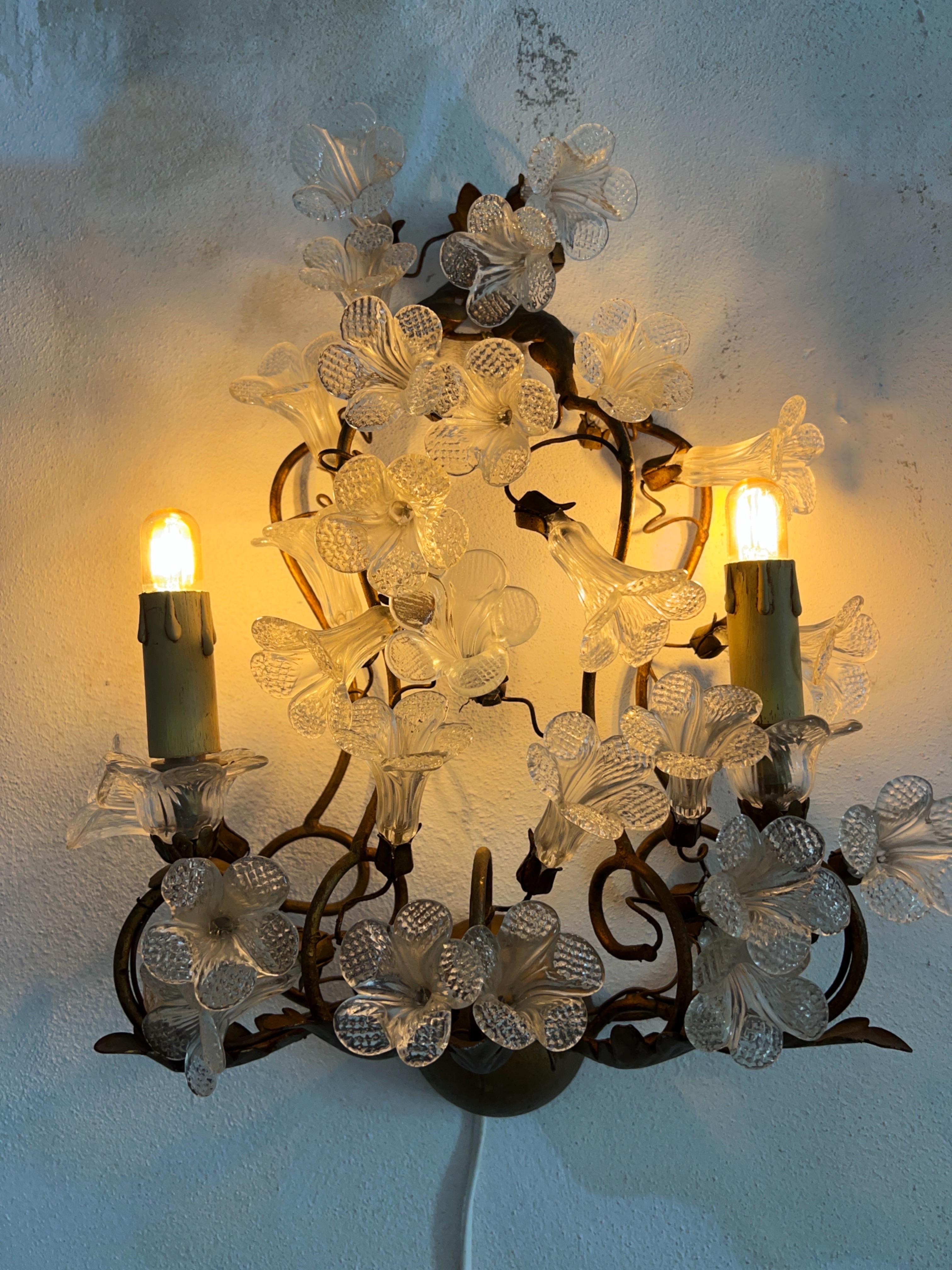 Lampada da parete in vetro di Murano con base in metallo forgiato rivestito d'oro degli anni '50

Questa elegante lampada da parete degli anni '50 è caratterizzata da fiori in vetro di Murano trasparente delicatamente disposti su una base in metallo