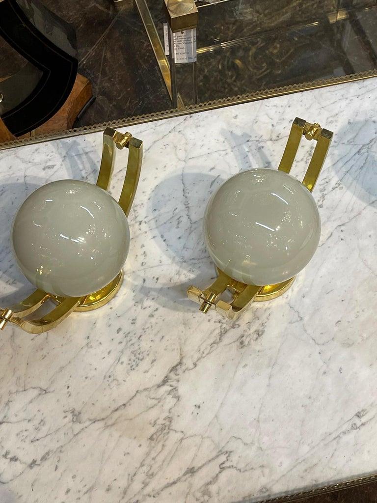 Pair of modern Murano glass and brass globe sconces, Circa 2000. The sconces are wired and ready to hang. Sure to make a statement.