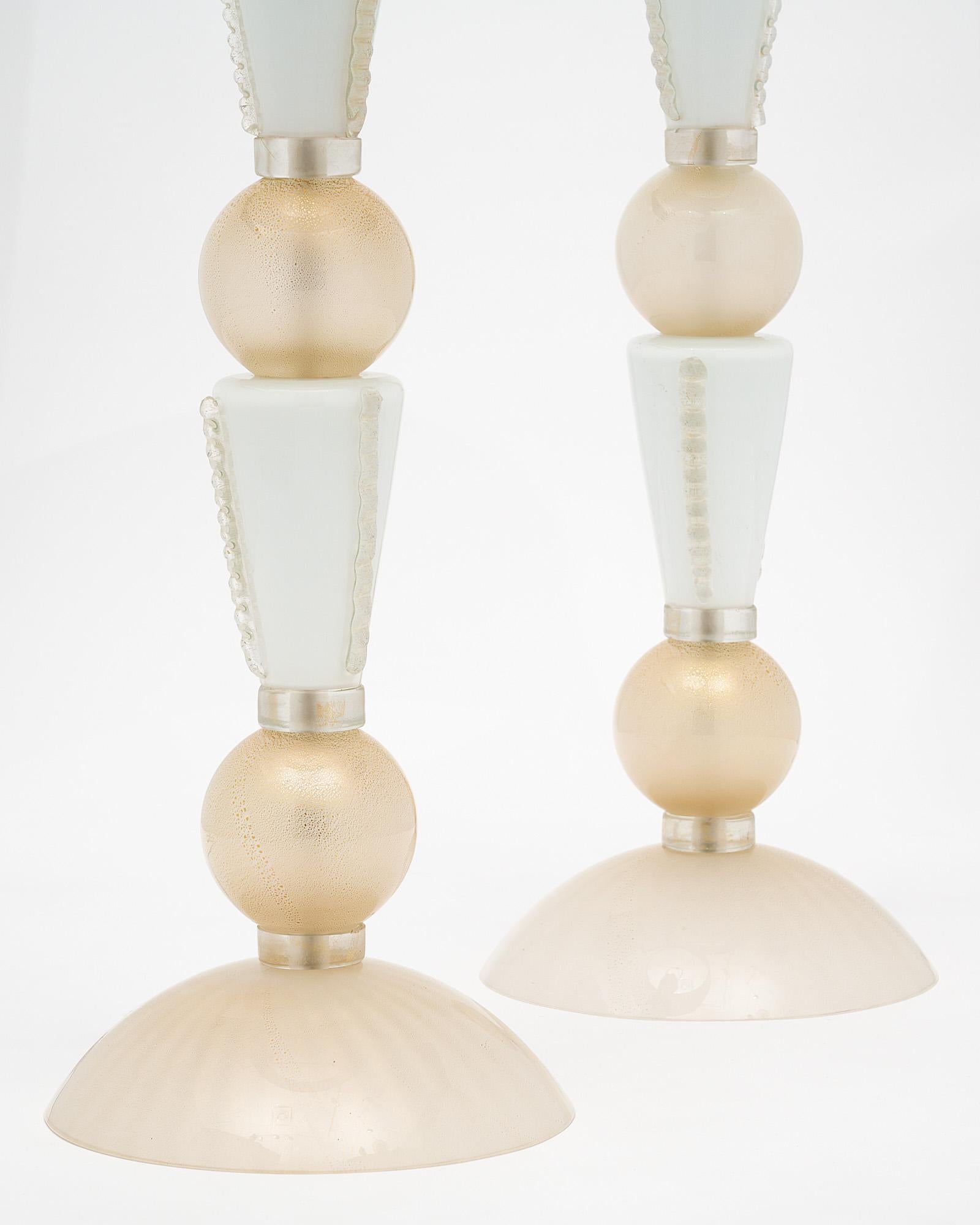 Pair of Murano glass lamps from Italy. This hand blown pair of lamps features alternating glass components between spheric and conic, gold and white. The gold has avventurina 23 carat gold flecks fused throughout. They have been newly wired to fit