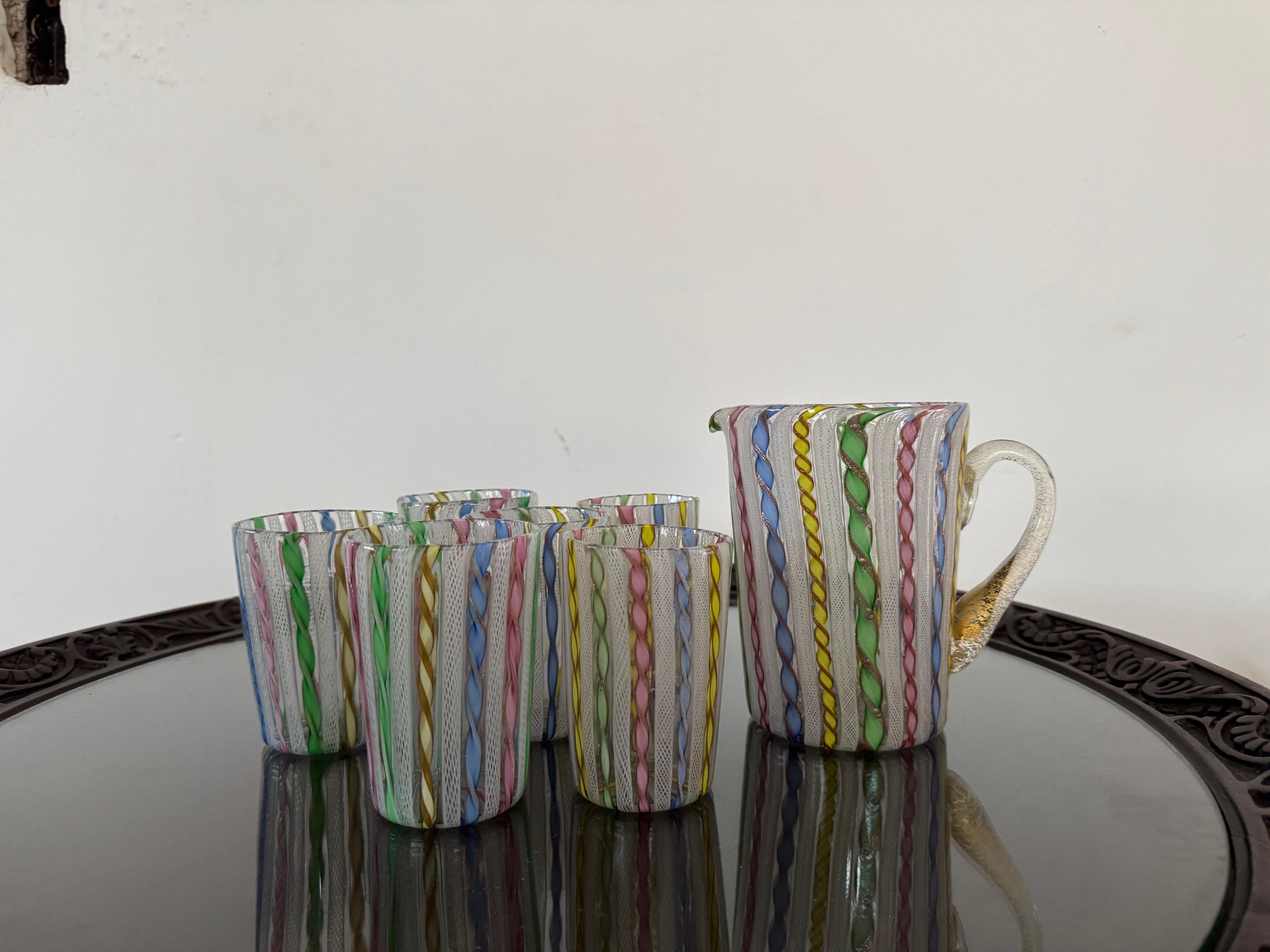 Beautiful and rare set of 6 cups and a Pitcher in Murano glass, all executed in the ‘Zanfirico’ technique, invented in 19th century and involves twisting and shaping glass canes to create intricate, spiral patterns and requires a master glass blower