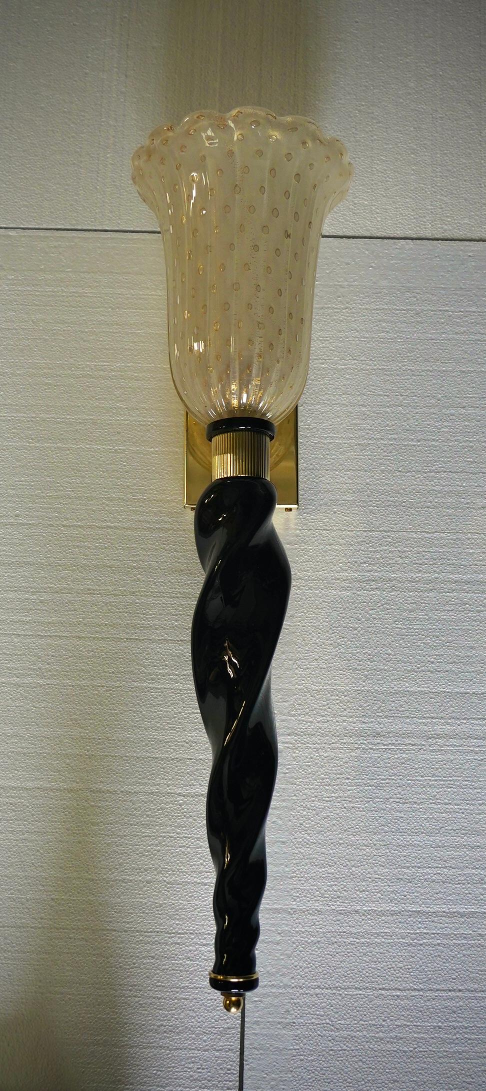 Design raffinato e delicato per questa coppia di applique in vetro di Murano color oro e nero.

L'applique ha una struttura in ottone, sulla quale è stata montata una bellissima coppa in vetro di Murano color oro nella parte superiore, che contiene