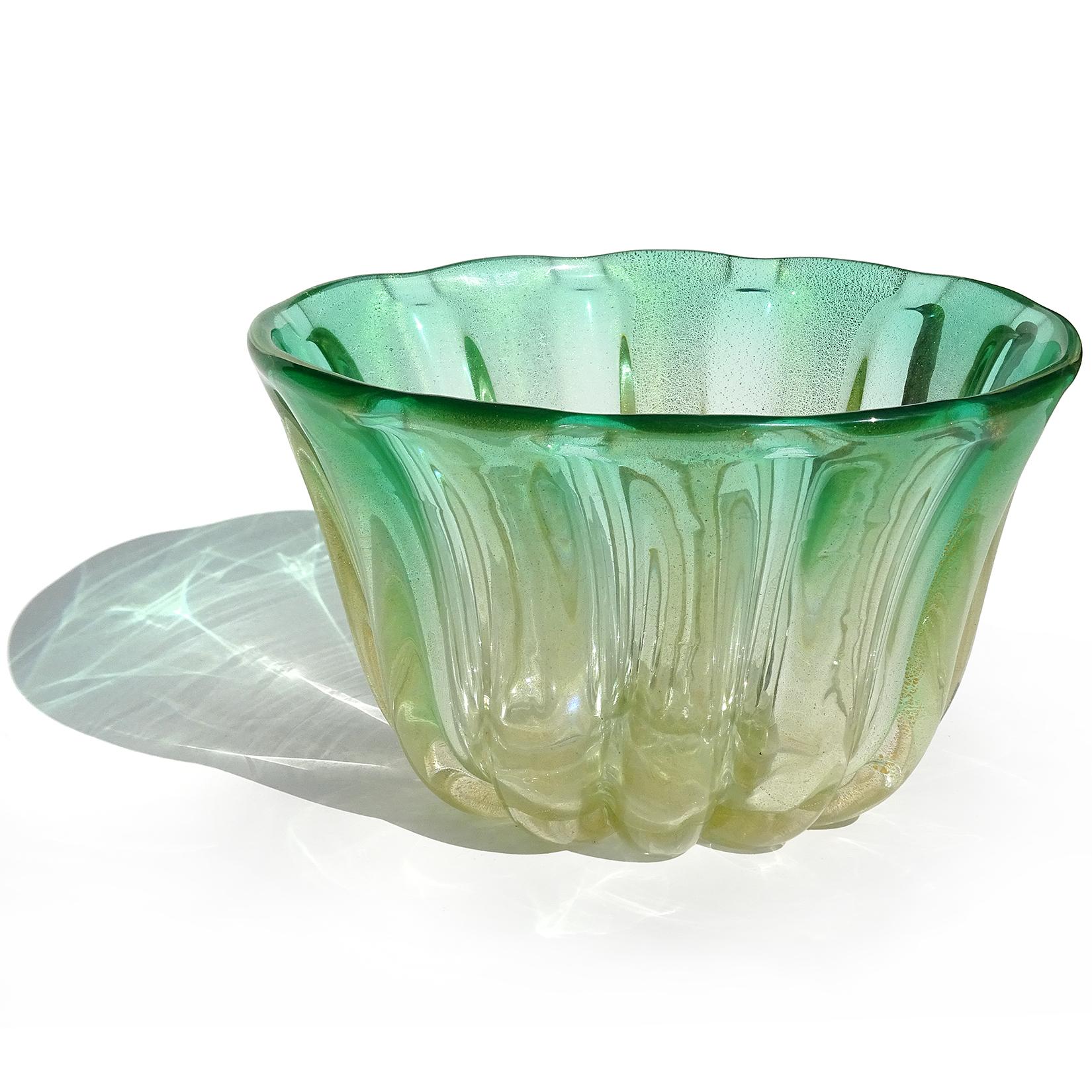 Priced per item (2 available). Beautiful vintage Murano hand blown Sommerso green and gold flecks Italian art glass bowl / vase. It has a green rim that fades to clear at the bottom. Profusely covered in gold leaf, with a ribbed surface. Tall enough