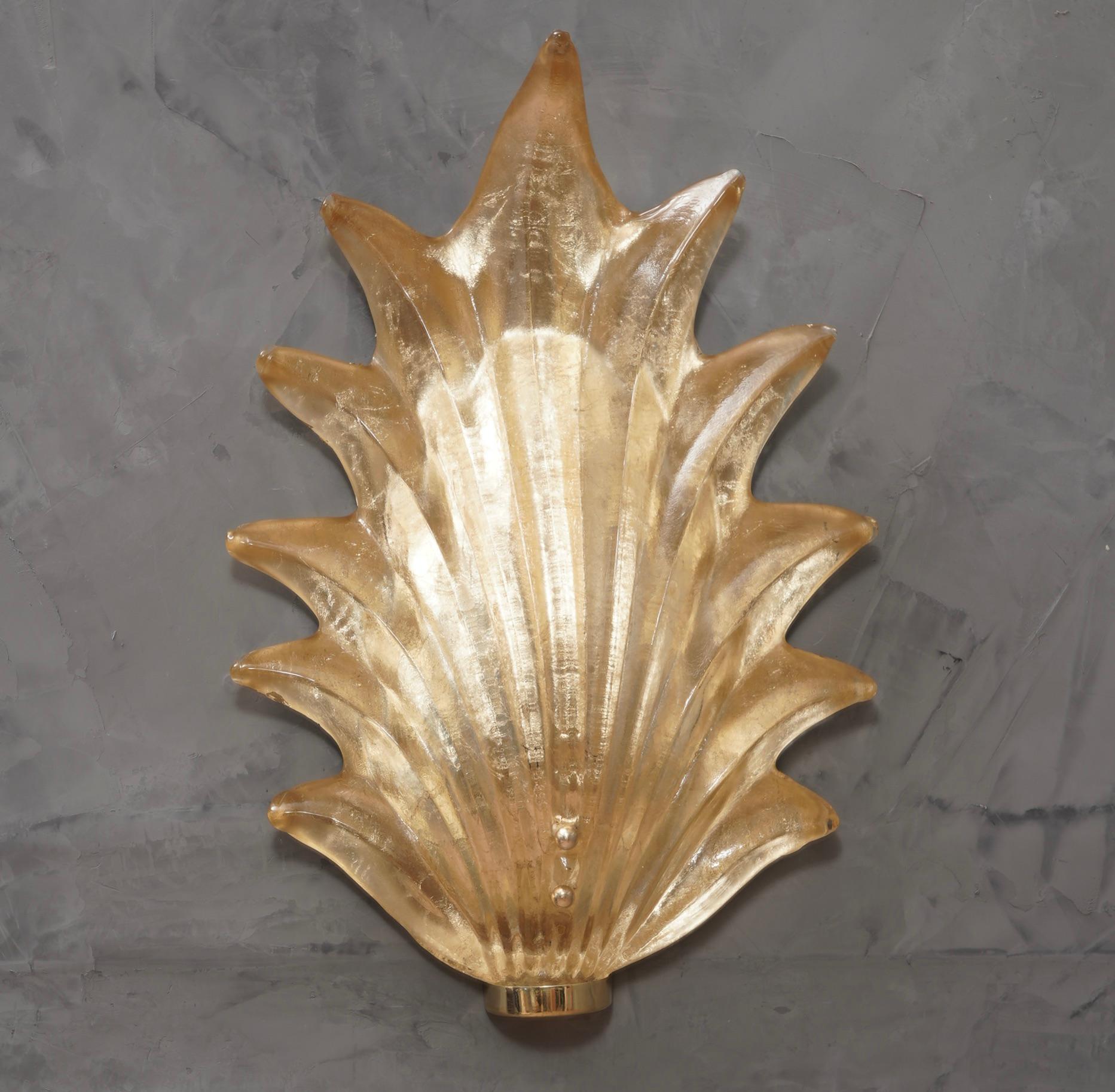 Majestic leaf in Murano glass of a wonderful gold color, made even more beautiful by the polished brass base.

The applique is composed of a brass structure that is attached to the wall by means of plugs and a large gold Murano glass leaf inserted
