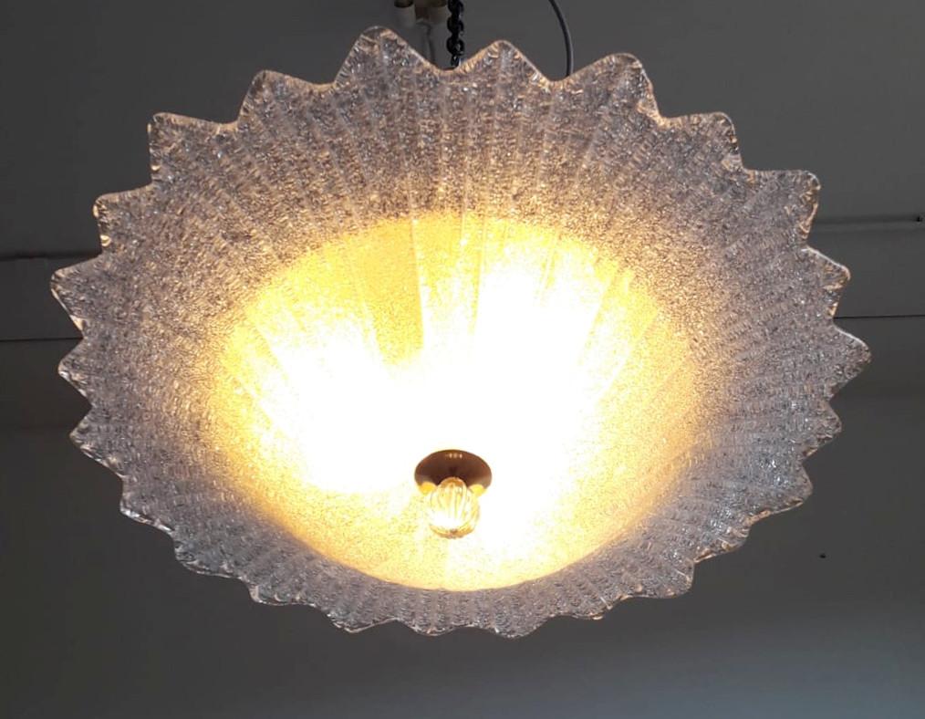 Vintage Italian flush mount with a single large textured clear Murano glass diffuser hand blown in Graniglia technique, mounted on gold finish metal frame / Made in Italy, circa 1960s
Measures: diameter 27.5 inches, height 7 inches
3 lights / E26 or