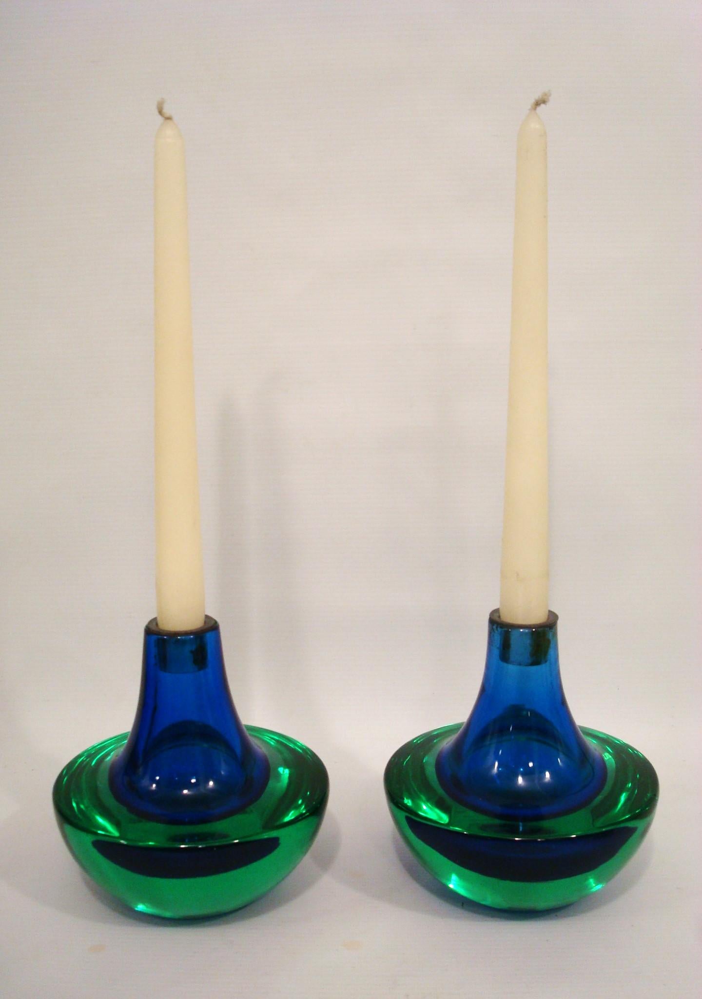 Murano Green and Blue Glass Mid-Century Candelabras / Candle Holders. Italy 1970. Sommerso style lovely pair of heavy candle holders. In Good conditions.
These glass pieces captivates with its sinuous curves and vibrant interplay of blues and