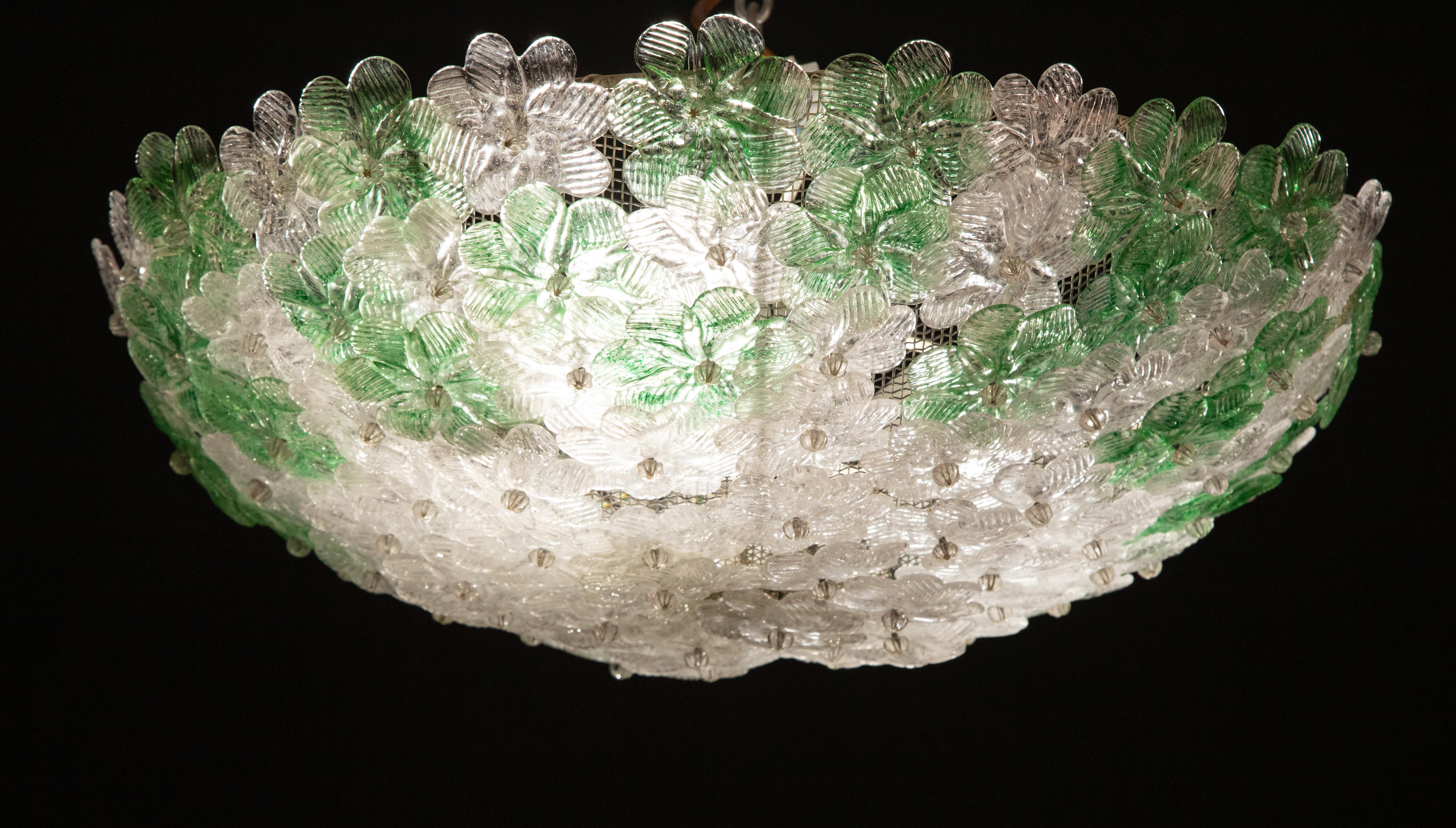 Elegant six-light ceiling lamp with Murano glass flowers, made by Barovier e Toso.
White-painted metal ceiling basket with overlapping flowers made of hand blown Murano glass in green and transparent color with gold inclusions, attached