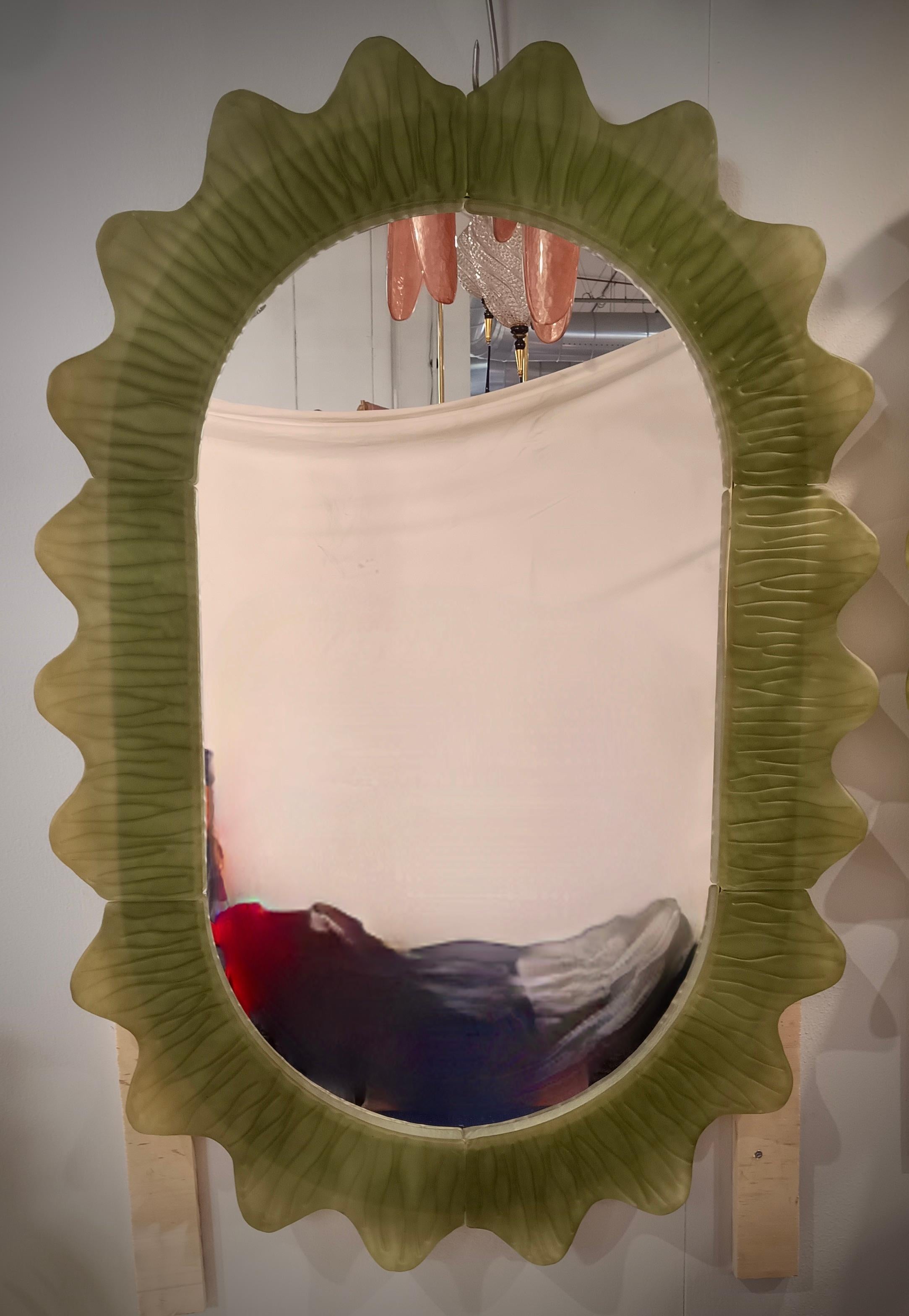 Magnifique miroir en verre de Murano de couleur verte. Un miroir qui, à lui seul, meublera votre environnement domestique. Riche mais de bon goût, le miroir présente un design vraiment particulier, avec une très belle forme de ces sections de