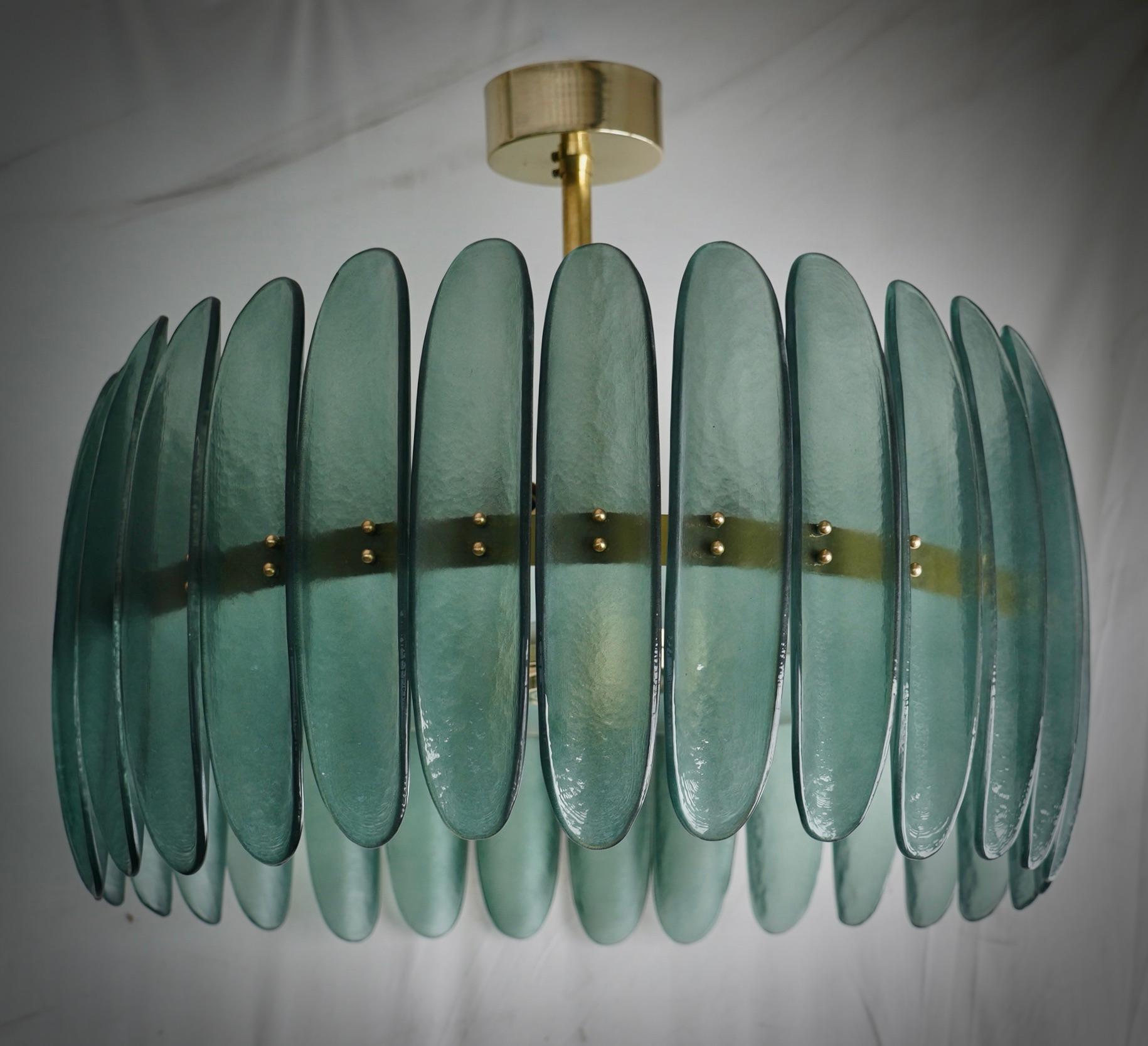 Fantastic round chandelier in Murano glass and polished brass. Note the shape of the half shells in green Murano glass, very beautiful and particular. Linear Murano chandelier, simple but very elegant.

Murano chandelier in green artistic glass and
