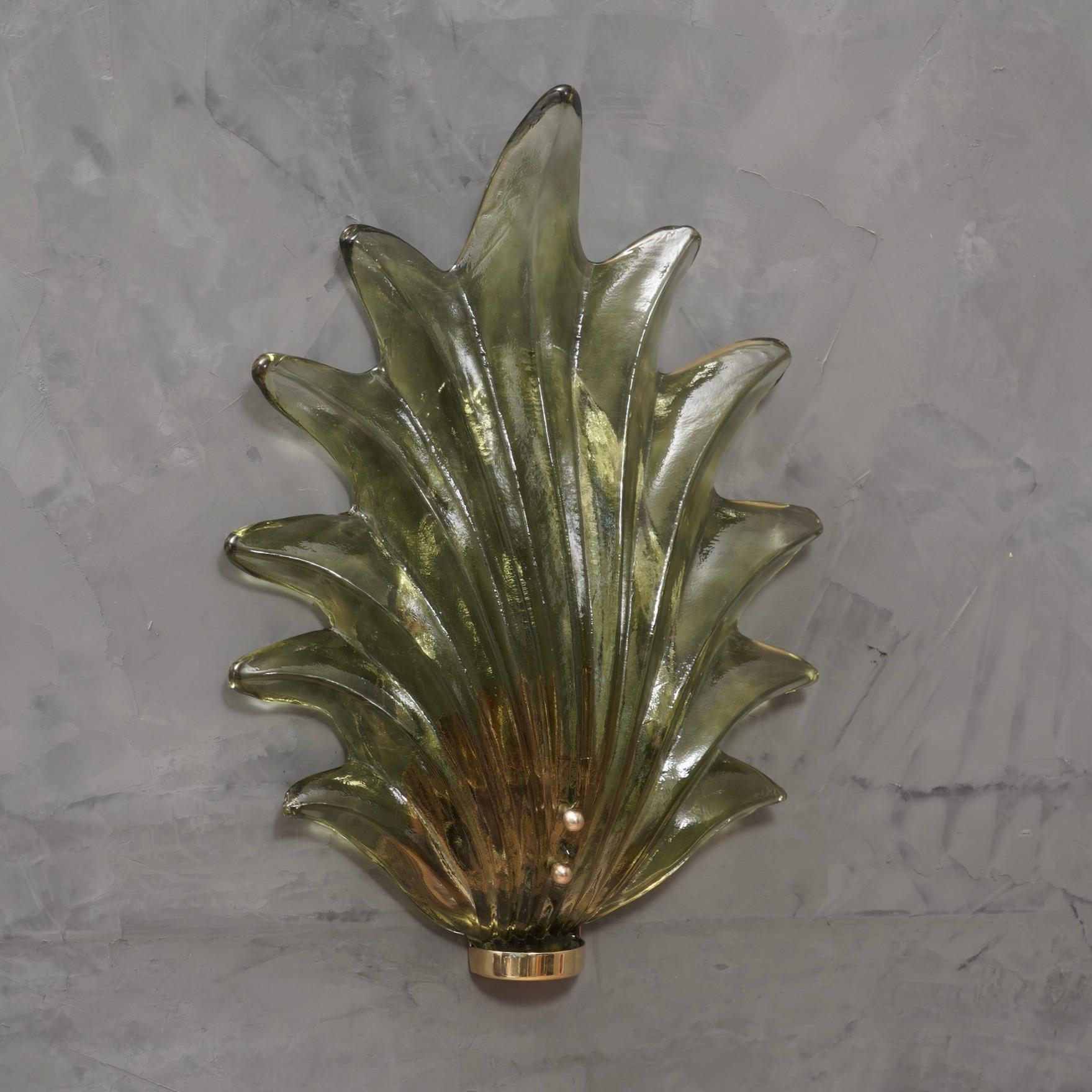 Majestic leaf in Murano glass of a wonderful green color, made even more beautiful by the polished brass base.

The applique is composed of a brass structure that is attached to the wall by means of plugs and a large green Murano glass leaf inserted