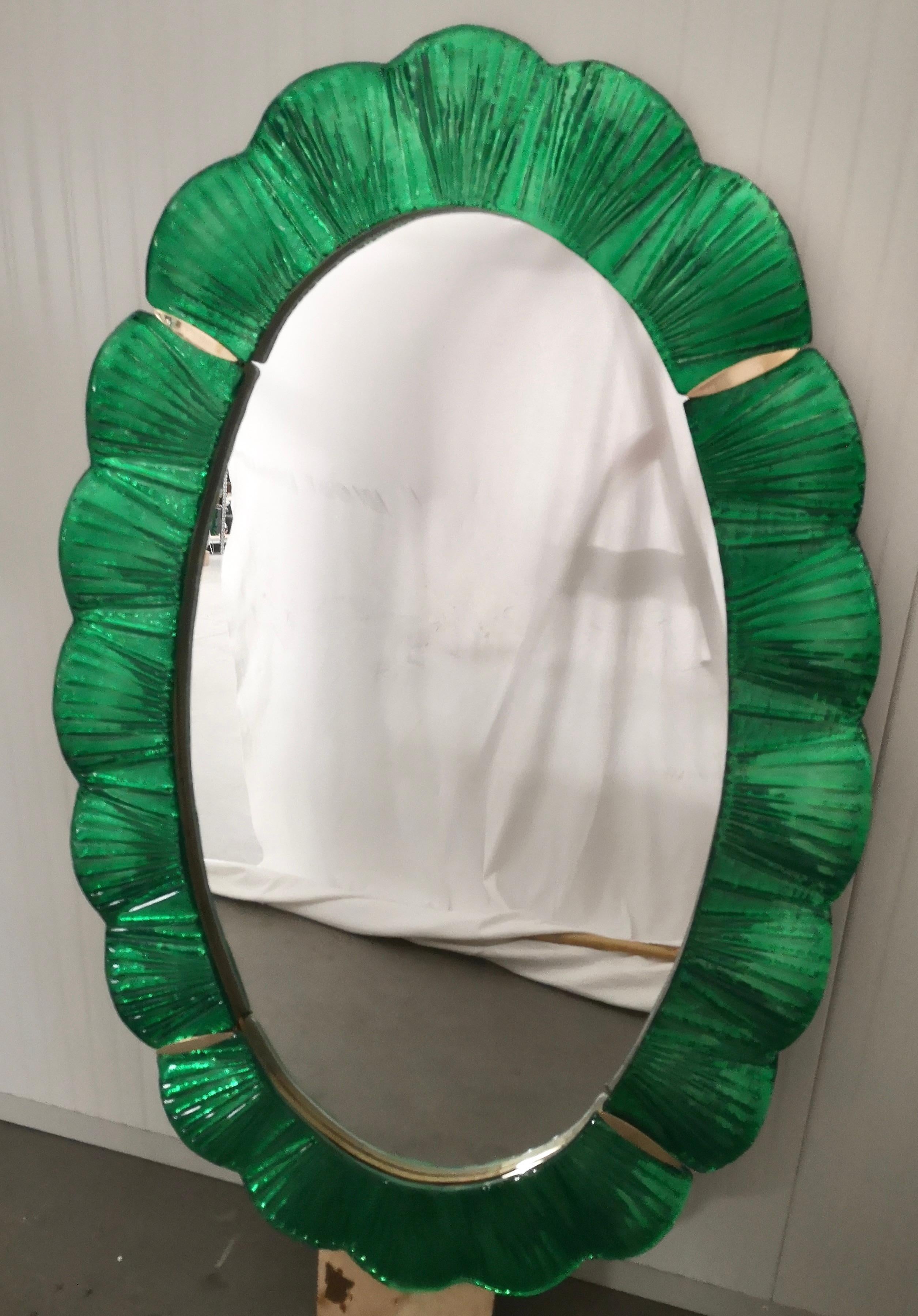 Atemberaubende Spiegel in leuchtend grüne Farbe Murano-Glas, Venedig. Ein Spiegel, der allein Ihr Zuhause einrichtet.

Der Spiegel hat eine Rückwand aus Holz, auf der vier Muranoglasscheiben montiert sind, die wie auf dem Foto ein Oval bilden. Der