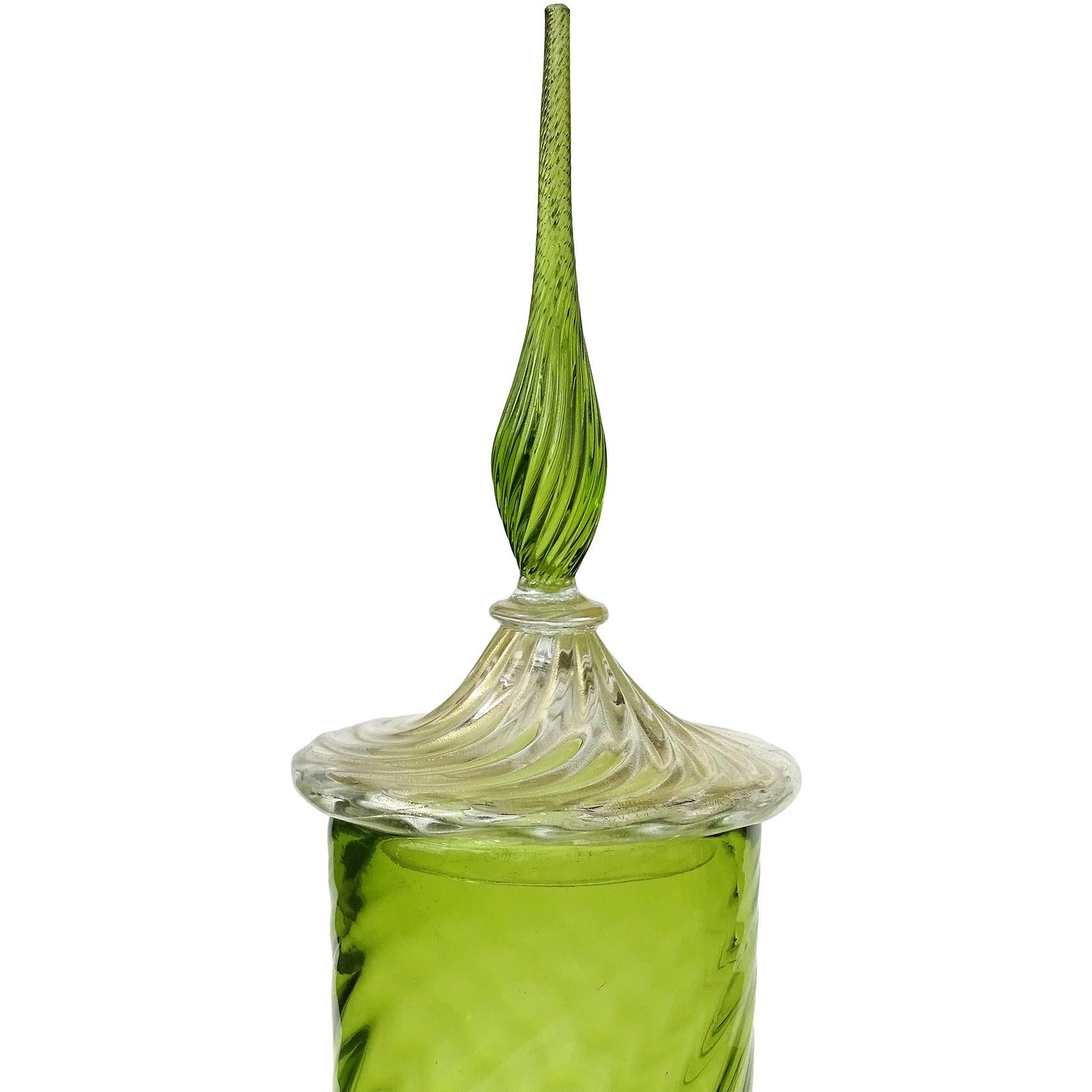Gorgeous, and very tall, vintage Murano hand blown apple green with gold flecks Italian art glass tall decanter / candy jar. It has a soft ribbed surface on the body, and more pronounced on the lid, and applied foot. The lid and base are covered in