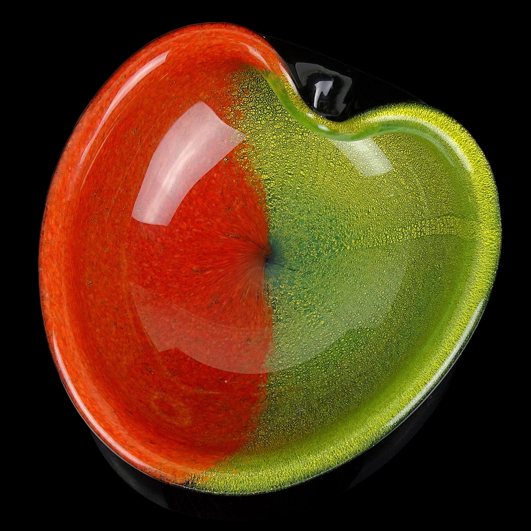 Precioso cuenco vintage de Murano soplado a mano en forma de corazón de vidrio artístico italiano con motas negras, rojas, verdes y doradas. La pieza tiene el exterior negro, con colores rojo y verde claro en el interior. El verde es muy