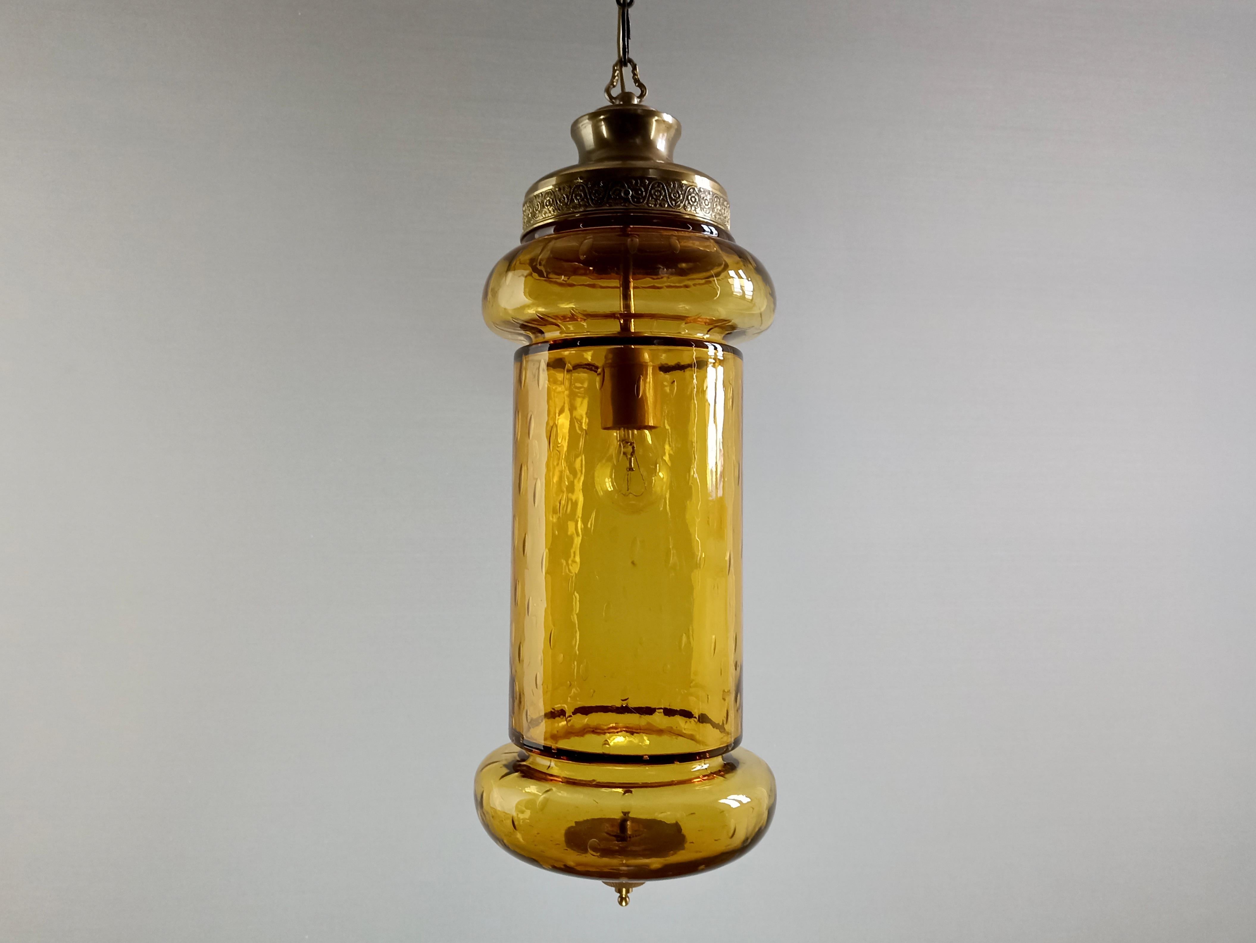 Very distinctive and impressive Murano hand-blown glass one-light ceiling lantern from the 1950s! 
The lantern consists of a thick yellow/gold blown glass body with the particular Bulicante workmanship. 
The frame is made of brass and has a
