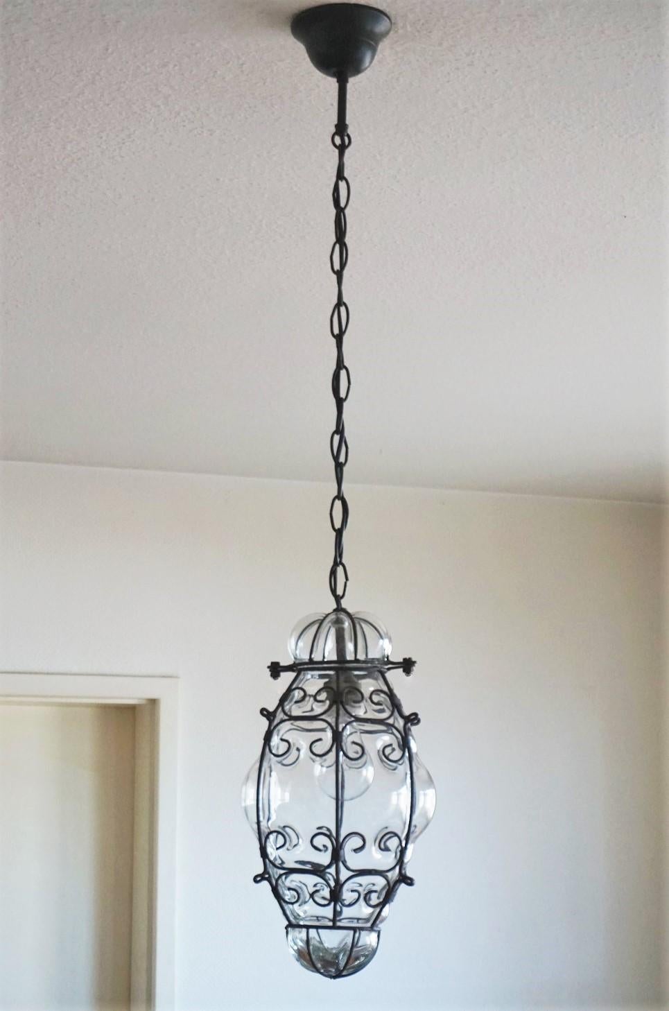 A lovely vintage Venetian hand blown clear glass in wrought iron frame pendant or lantern, Italy, 1930s. This pendant is for indoor and outdoor use.
One E27 light socket for a large sized bulb up to 100W.
Measures:
Total height 39