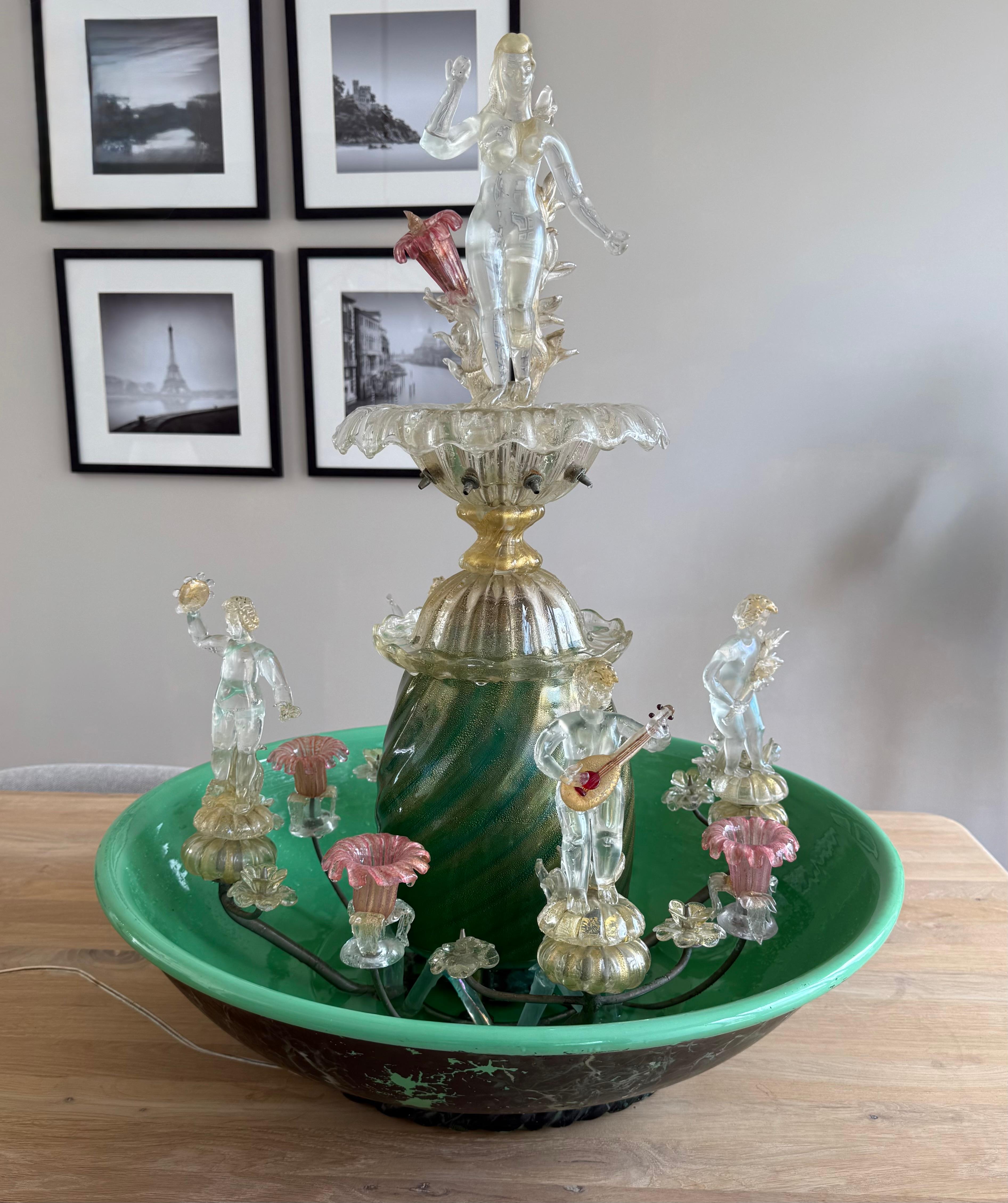 Incredibile fontana da tavolo e lampada in vetro soffiato a bocca realizzata a mano.

Questa rara fontana da tavolo in vetro di Murano è una spettacolare fusione di scultura, luce e acqua: un vero capolavoro. Attribuito allo studio di Gino Cenedese,
