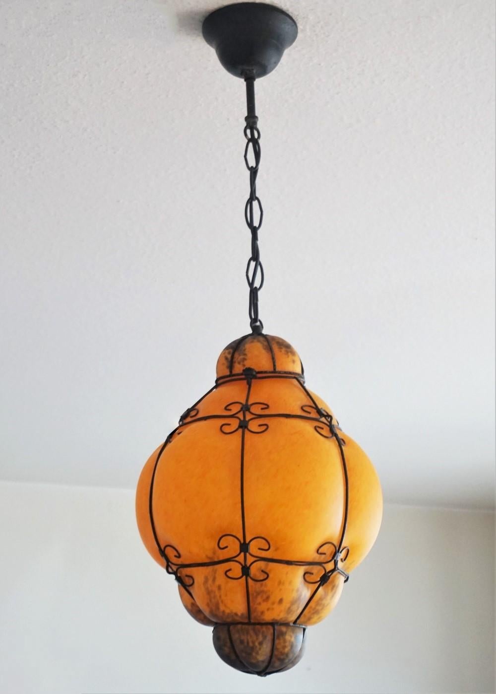 Murano hand blown colored glass in wrought iron frame pendant, orange, yellow and green colors with great lighting effect, Venice, Italy, 1930s. This pendant is for indoor and outdoor use.
One E27 light socket for a large sized bulb up to