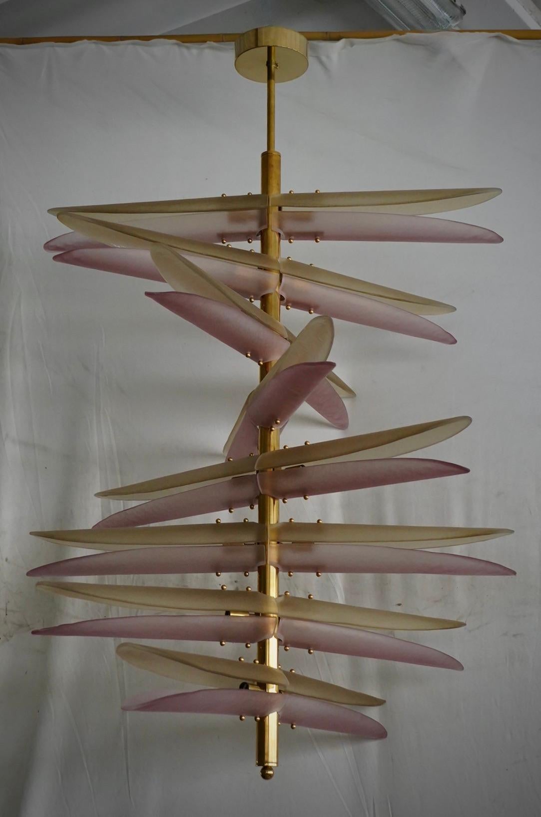 Dieser elegante Kronleuchter aus Murano-Glas mit seinen geschwungenen Linien ist ein schlichtes und geradliniges Stück von unglaublicher Schönheit, das Eleganz ausstrahlt. Die exquisite Handwerkskunst der länglichen Glasschalen trägt zur Eleganz