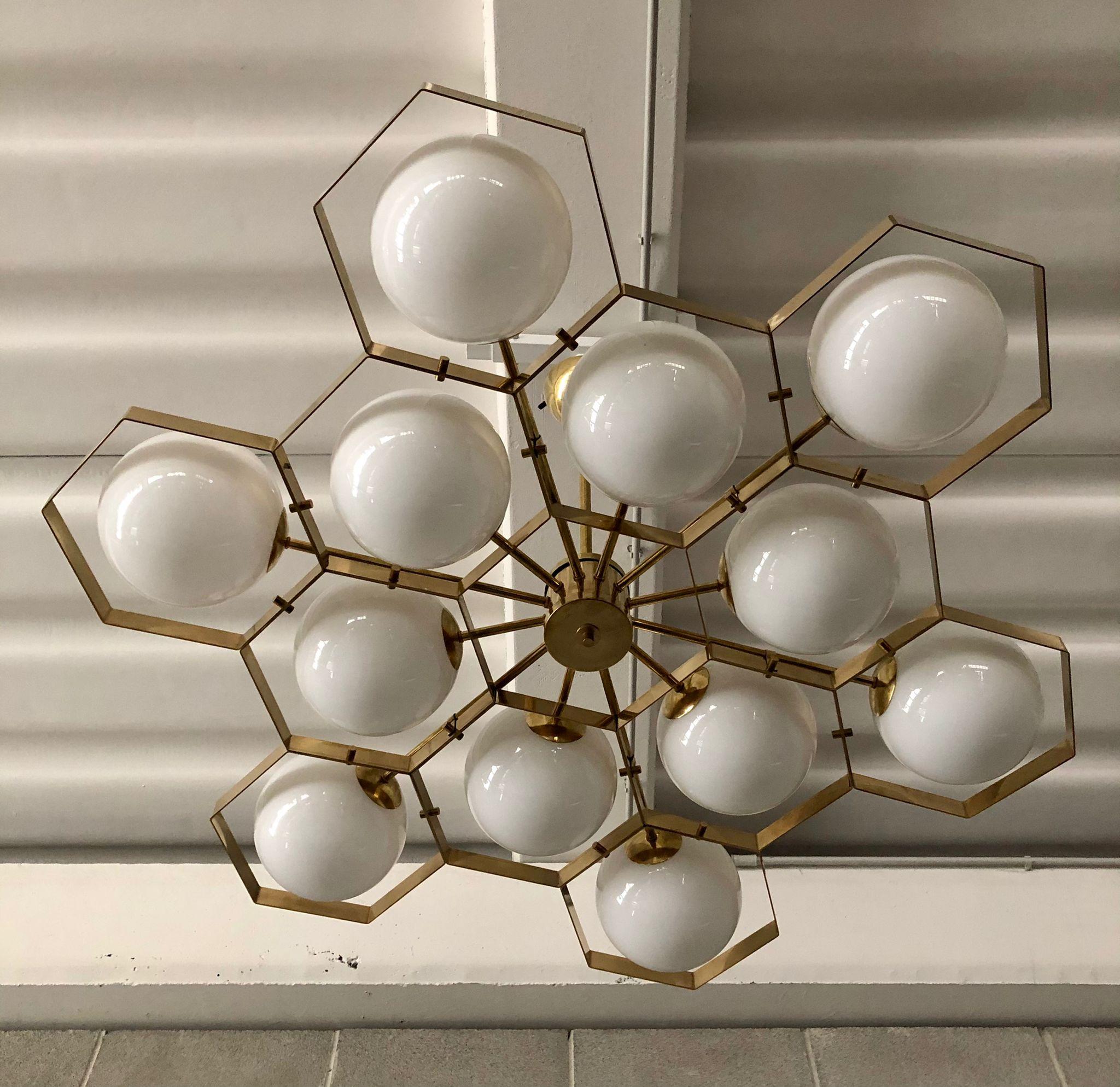 Superb chandelier for its characteristic hexagonal structure, unique design for the brass housing of the spheres.

The chandelier has a polished brass structure, it is composed of a series of brass hexagons joined all together. In the center of each