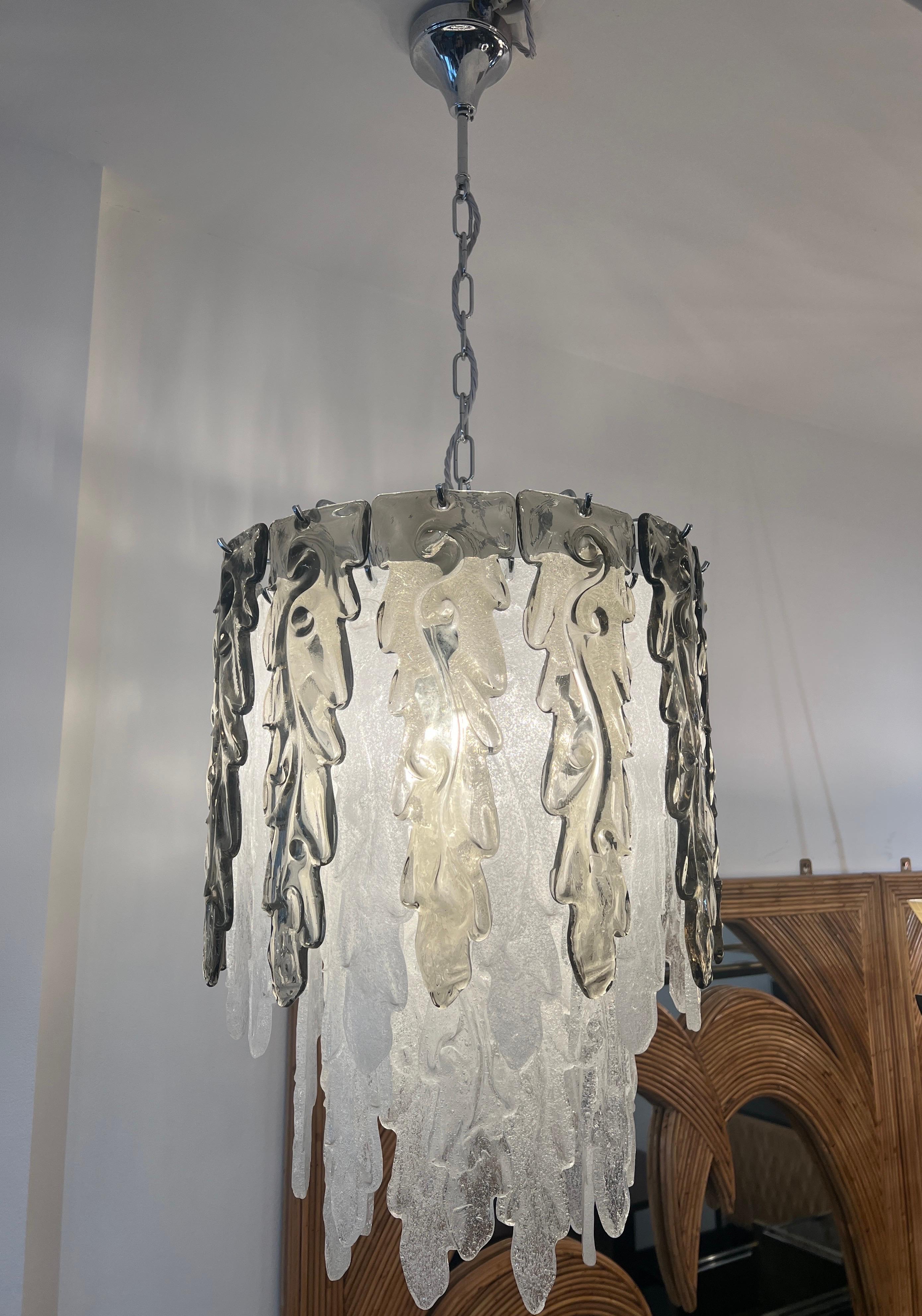 A beautiful cylinder body and chromed metal structure chandelier decorated with individually hand blown Murano glass leafs in ice white and olive green . C1970 Murano Italy . 
All measurements exclude the chain and the ceiling cap .