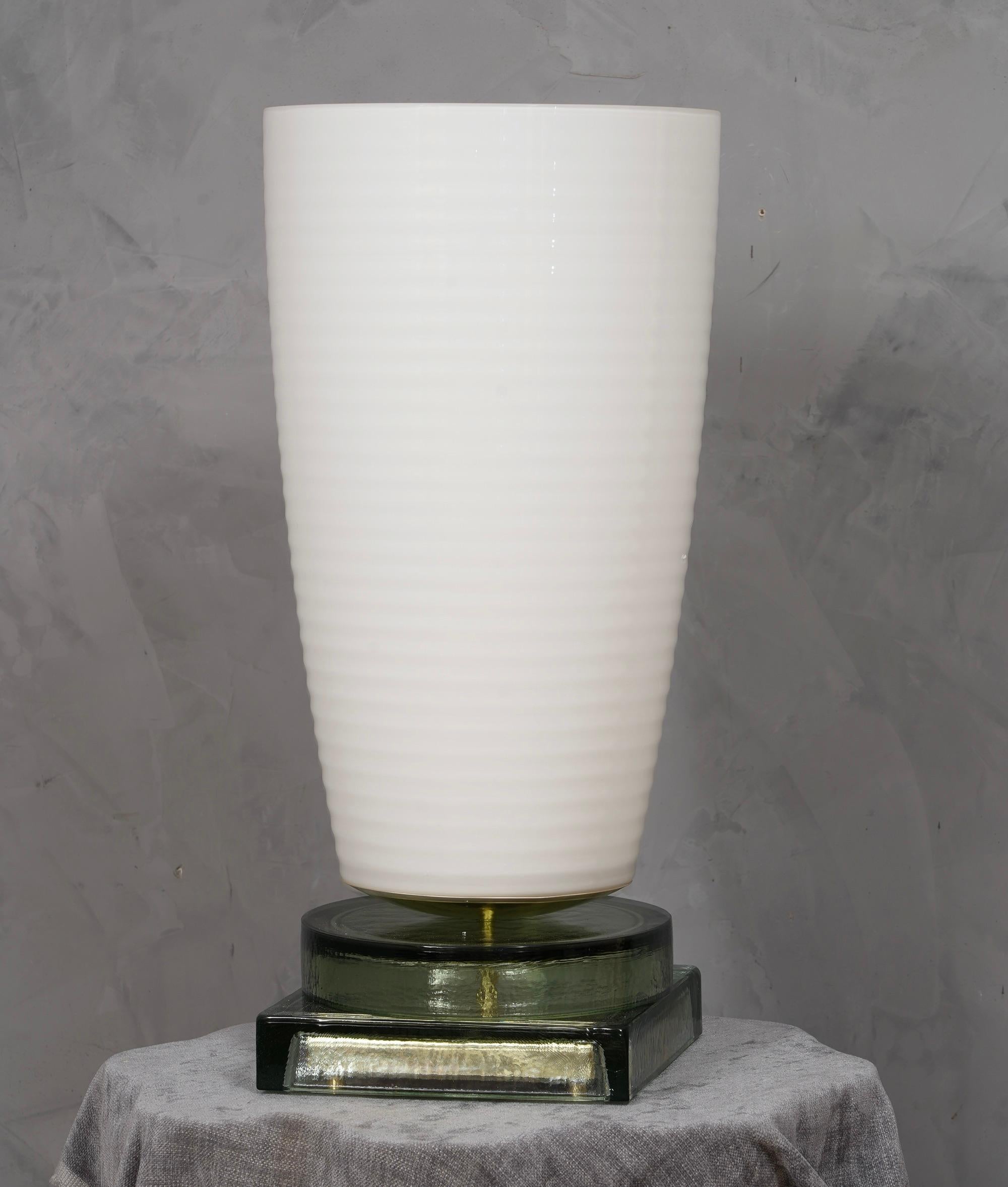 Kostbares und einzigartiges mundgeblasenes weißes Murano-Glas, klassisches, aber originelles Design mit einem starken Kontrast zwischen der großen weißen Vase und dem transparenten Glasboden.

Die Lampe zeichnet sich durch eine große weiße Vase mit