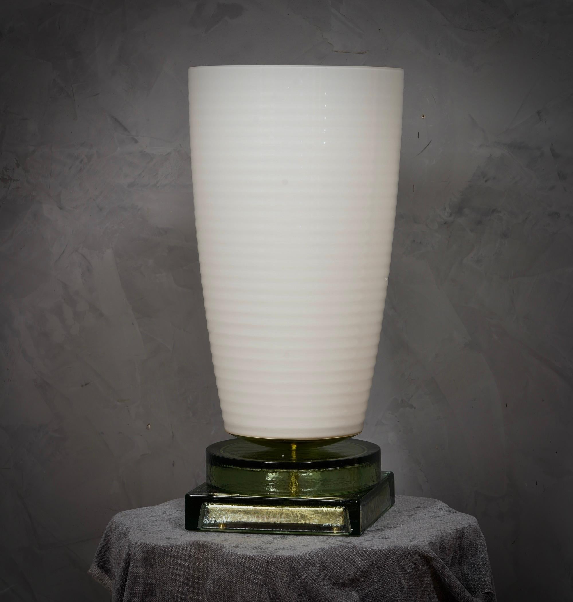 Kostbares und einzigartiges mundgeblasenes weißes Murano-Glas, klassisches, aber originelles Design mit einem starken Kontrast zwischen der großen weißen Vase und dem transparenten Glasboden.

Die Lampe zeichnet sich durch eine große weiße Vase mit