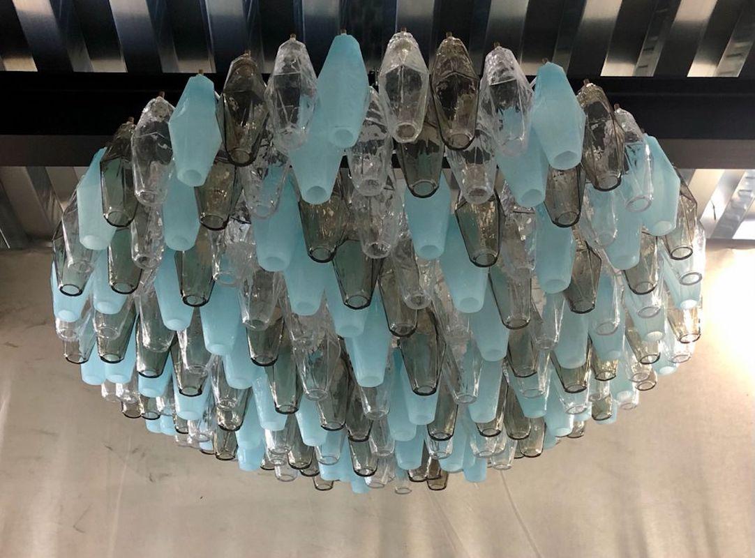 Splendid Murano glass chandelier with a particular 196 polychromy ranging from transparent to smoked and then to opal turquoise color. Its design is also very particular round but flattened in height.

The chandelier has a gray iron structure, with