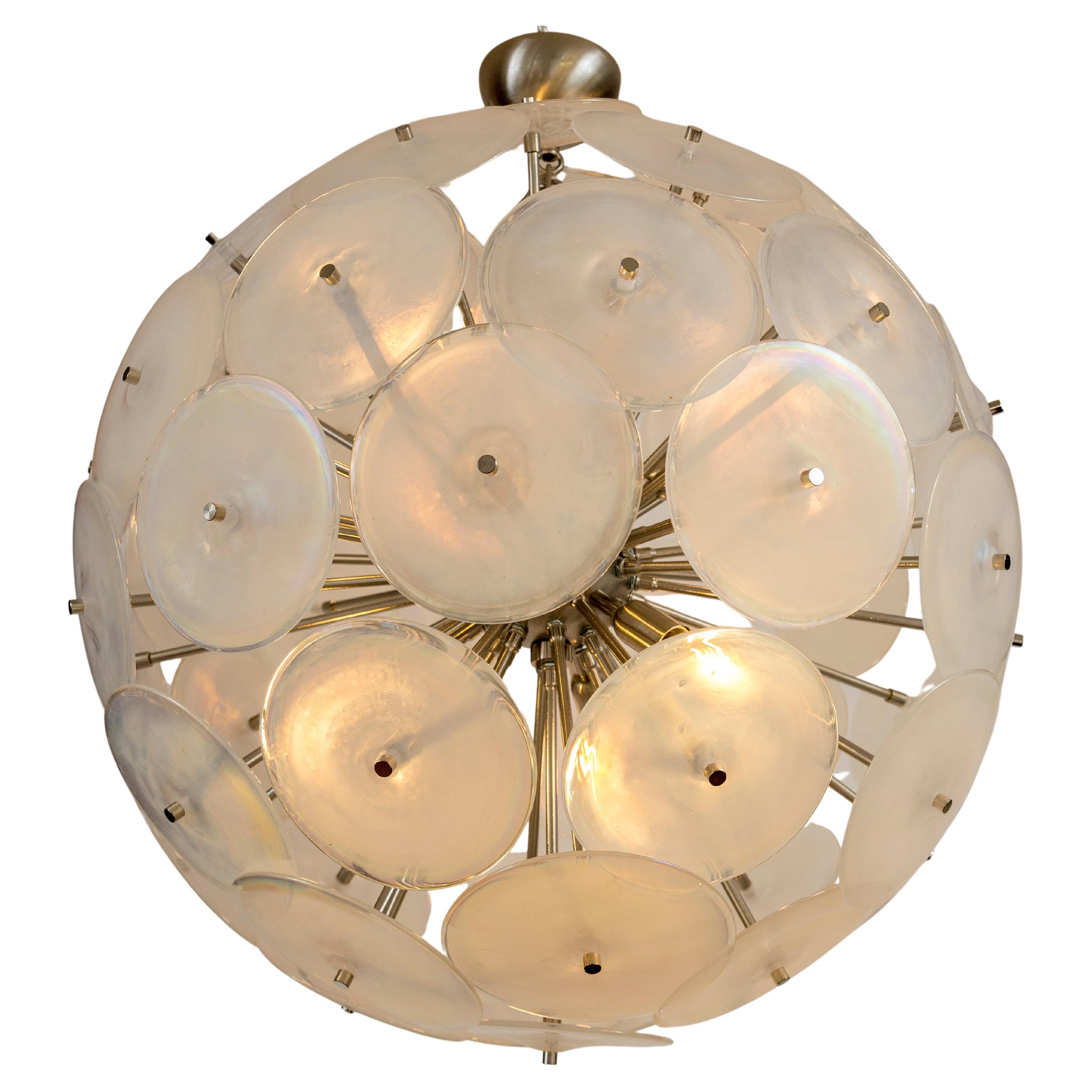 30 thickly blown iridescent white discs with clear glass edges comprise this matte nickel on brass Sputnik frame, illuminated with 6 candelabra bulbs to your desired overall drop of up to 54