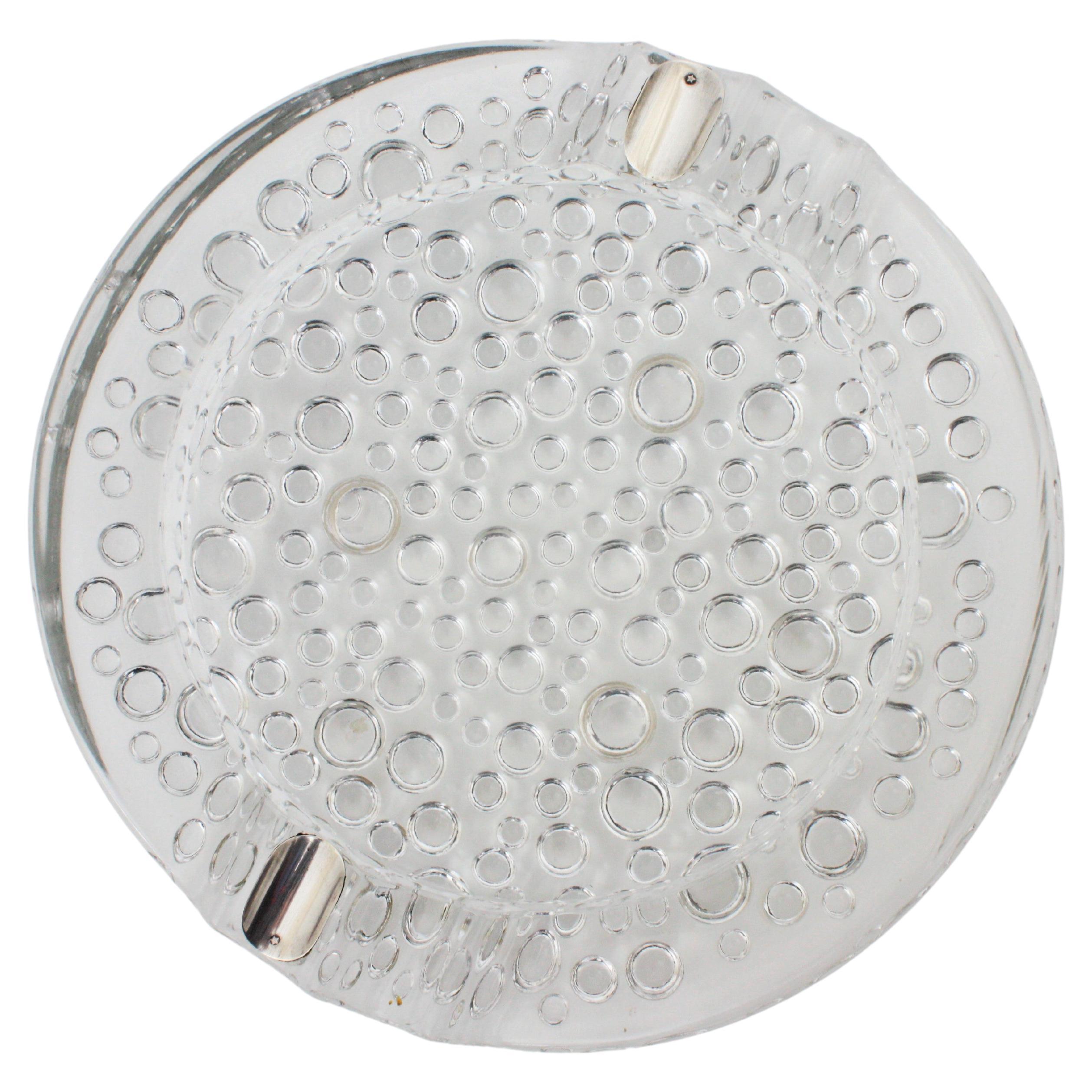 Cendrier en verre de Murano avec des millions de gouttes de bulles et des accents en argent sterling. Italie, années 1960.
Magnifique cendrier en verre d'art de Murano de forme circulaire, porte-cigarettes en argent sterling et magnifique
