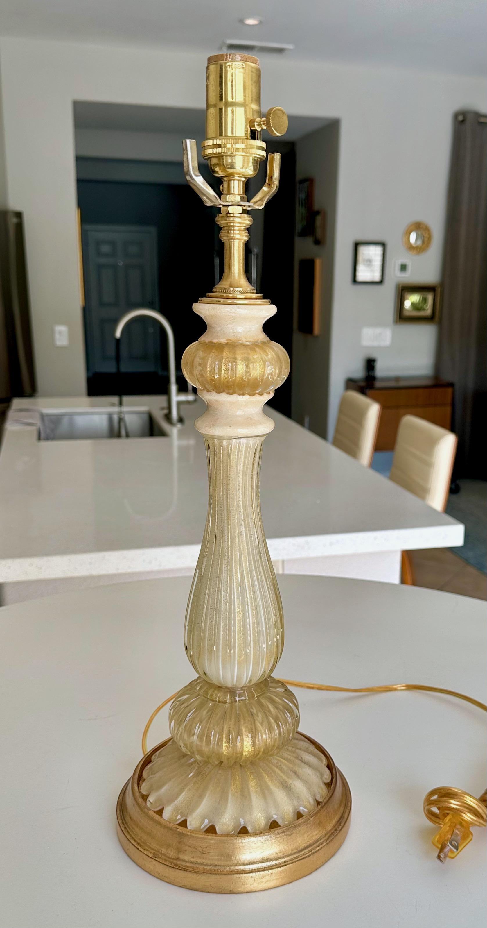 Lampe de table Murano des années 1950, soufflée à la main, de couleur crème et avec des inclusions d'or. Cette lampe est le fruit d'une conception et d'une minutie incroyables. Montée sur une base en bois doré, recâblée avec une nouvelle prise à