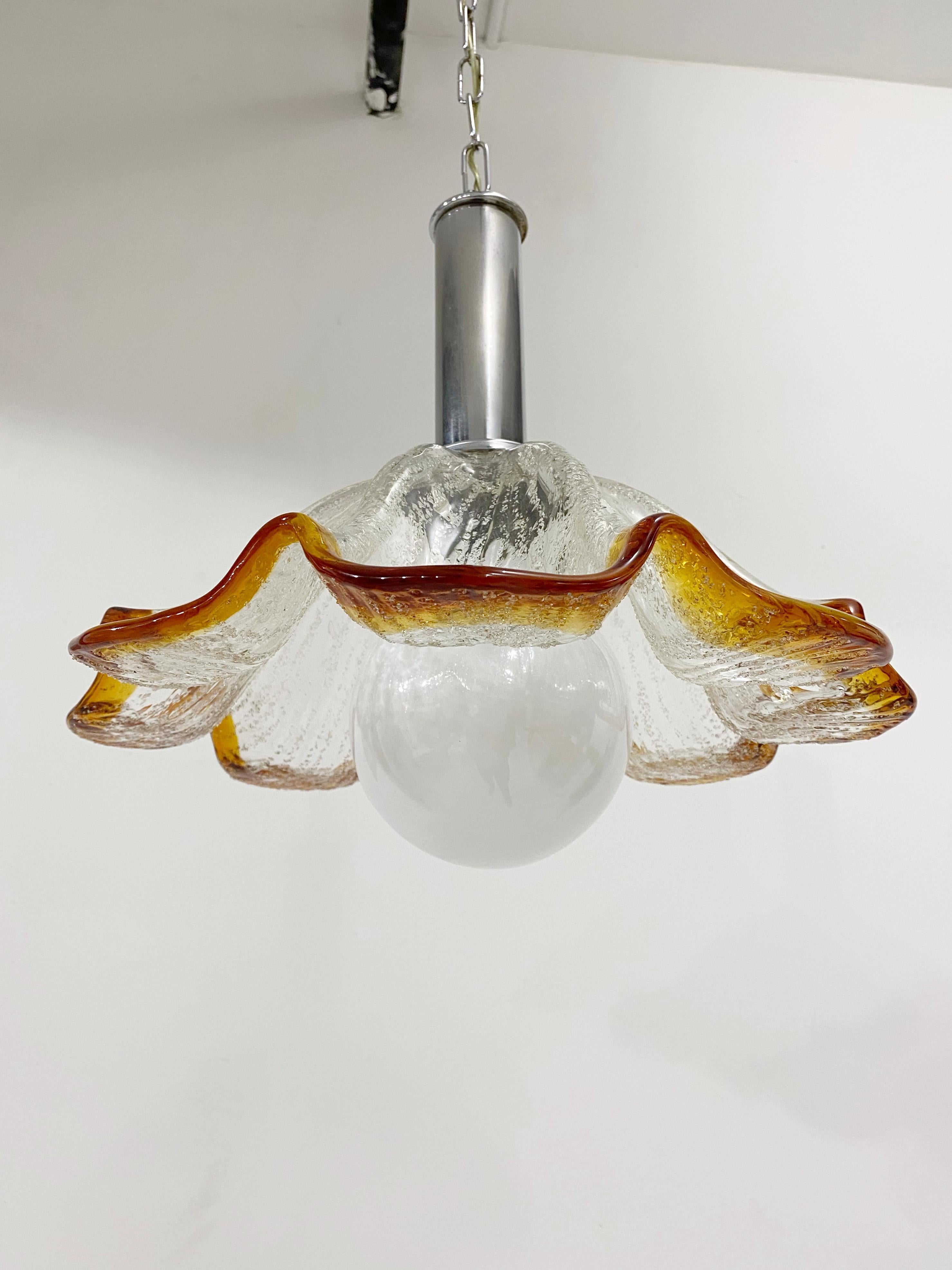 Stunning Murano chandelier pendant. Blown glass flower blossom held by tubular chrome. Fabulous ombré from clear to orange amber color. Includes chain and ceiling canopy, 24.5” long.