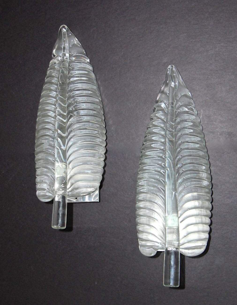 Pair of large heavy thick blown clear glass leaf Murano wall sconces. Backside of glass is satin textured providing a more even opaque light. Nickel backplates. Each sconce uses a single 60 watt max a base bulb. Rewired.
