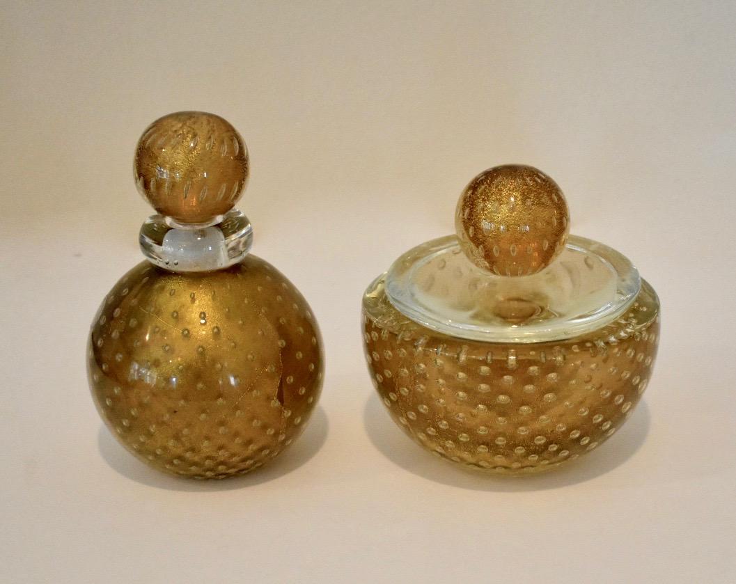 2-piece Murano glass set consisting of a stoppered bottle or jar and lidded bowl by Seguso, Murano, Italy. Thick cased clear glass surrounds a bronze colored interior with delicate gold inclusions control bubbles in between the two layers. Archimede