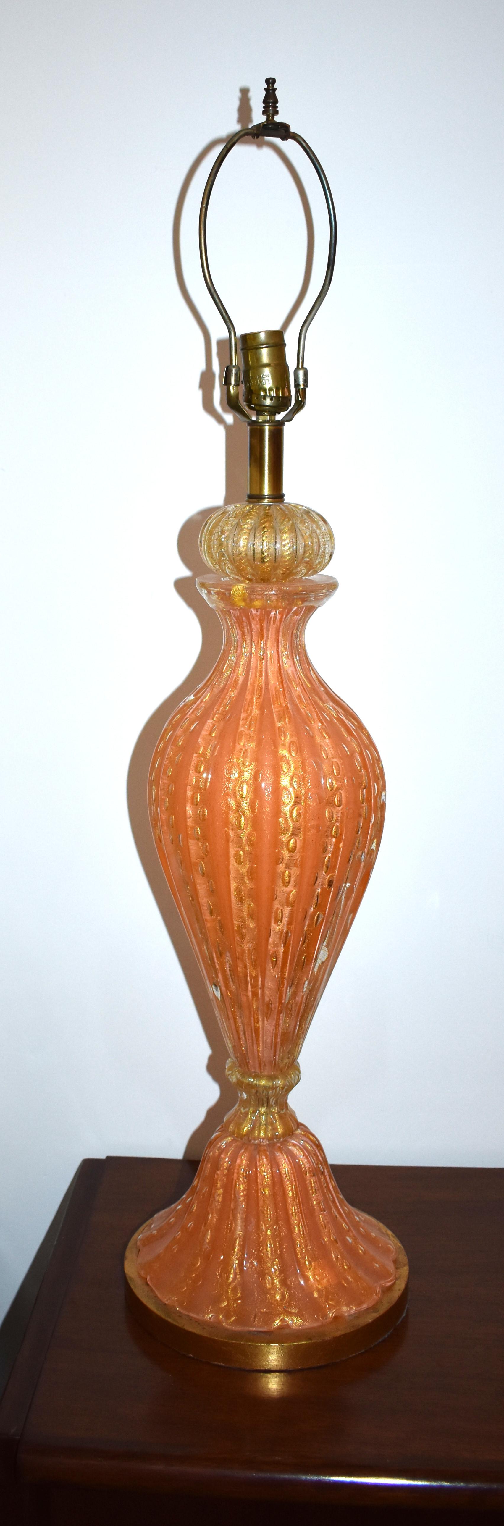 A single Murano hand blown orange and gold inclusions glass table lamp. The ribbed glass is thick and heavy with controlled bubbles and is mounted on gold finish wooden base.

Height of glass part only 24 inches.