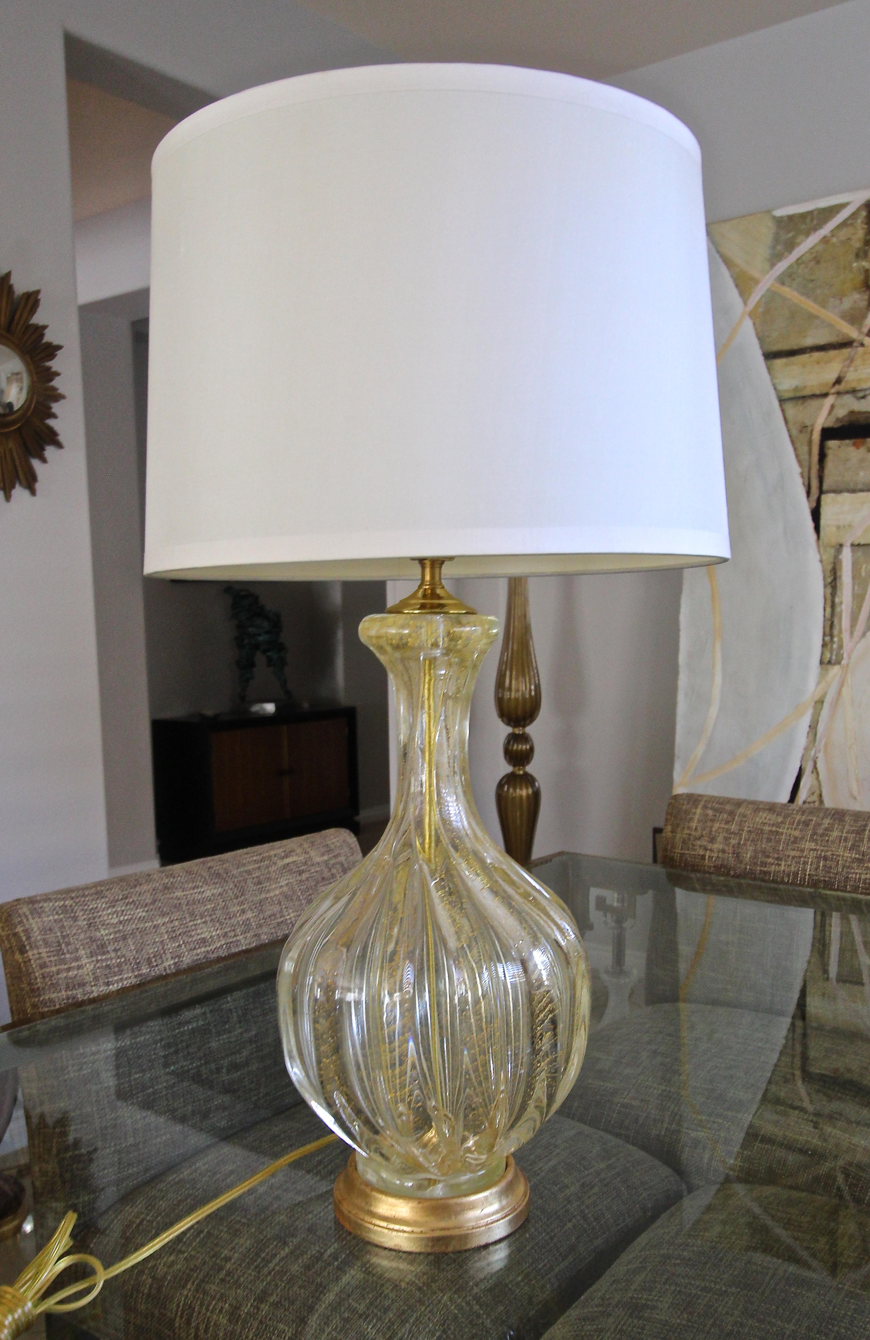A single Murano hand blown clear and gold inclusions glass table lamp. The ribbed glass is thick and heavy with controlled bubbles, and is mounted on new custom giltwood base. Newly wired for US with new solid brass fittings, 3 way socket and