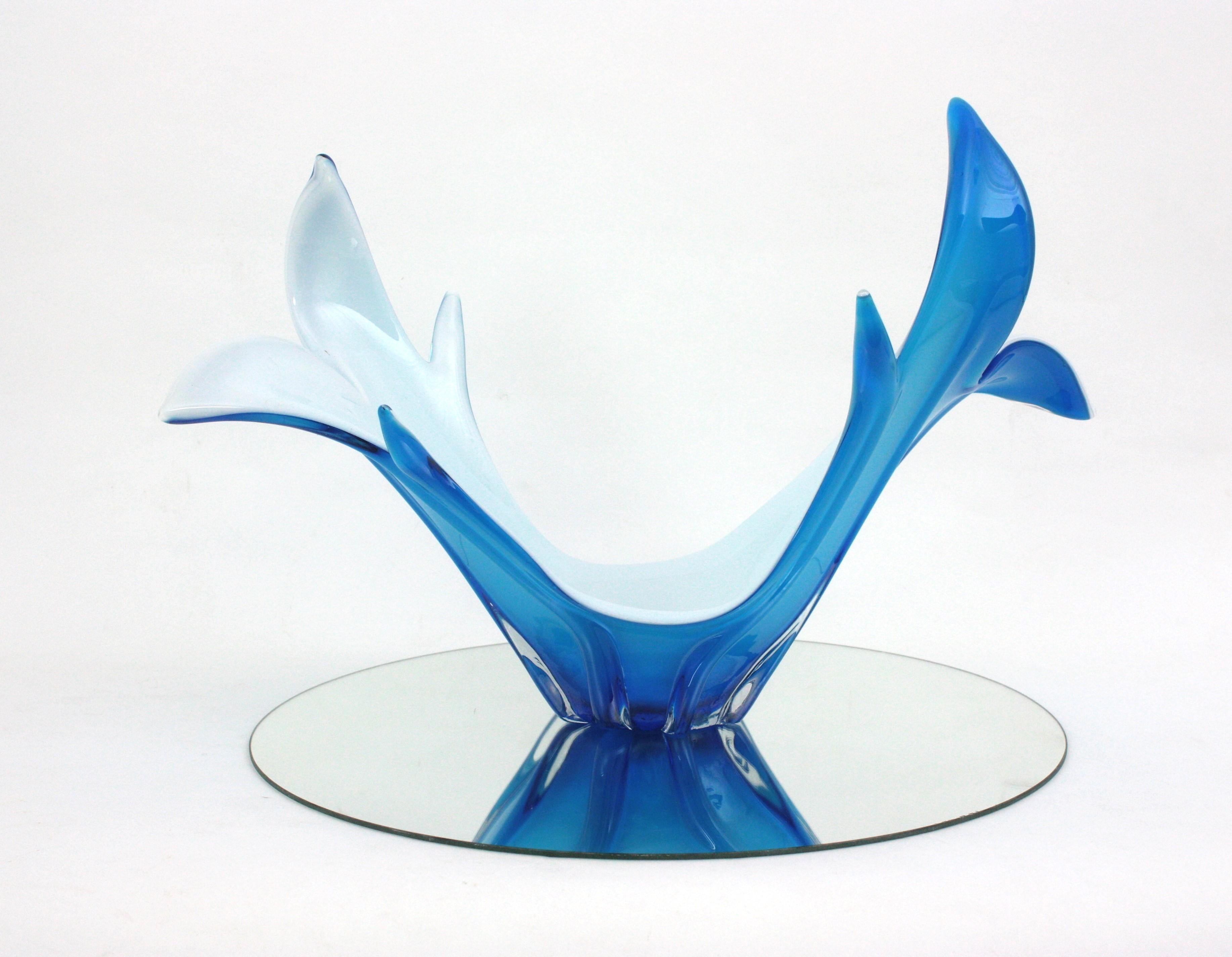 Centro de mesa / jarrón de cristal de Murano soplado a mano en azul cielo y blanco, muy decorativo y de diseño orgánico. Italia, años 60
Cristal azul encasquillado en cristal transparente. La parte interior es de cristal opalino blanco.
Será una