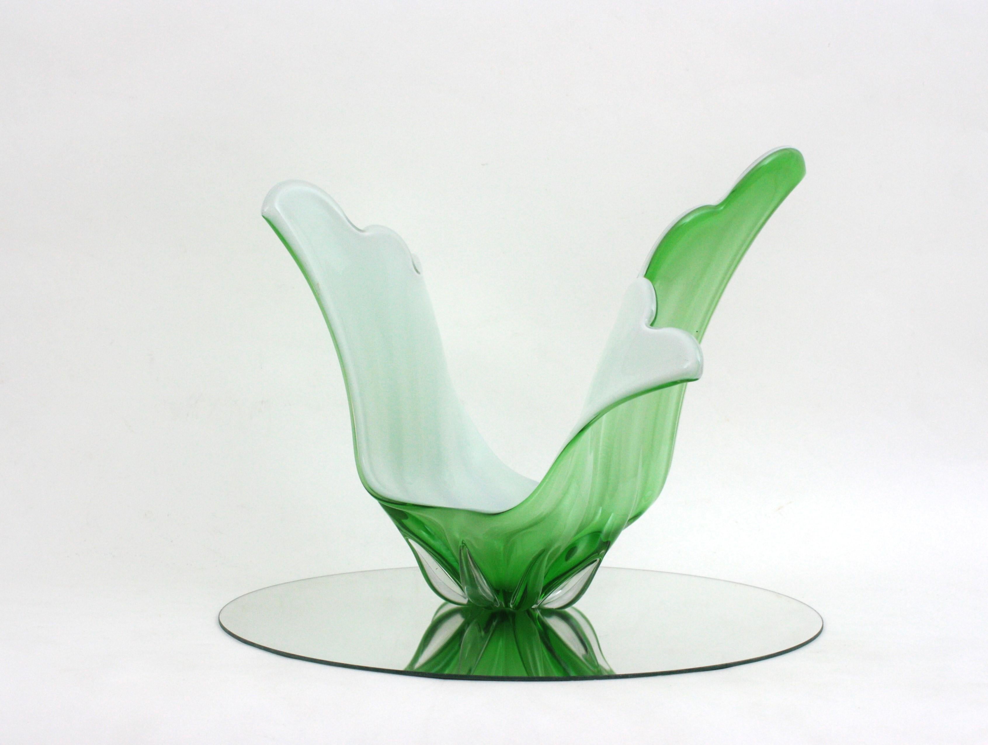 A highly decorative hand blown green and white Murano glass centerpiece / vase with organic design. Italy, 1960s
Pale green glass cased into clear glass. The interior part is made in white opaline glass.
It will be a nice choice for an urban